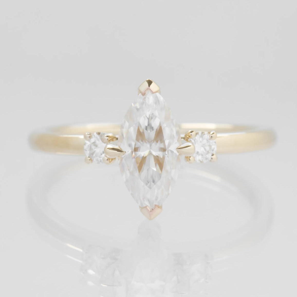 yellow gold 3 stone ring with moissanite marquise
