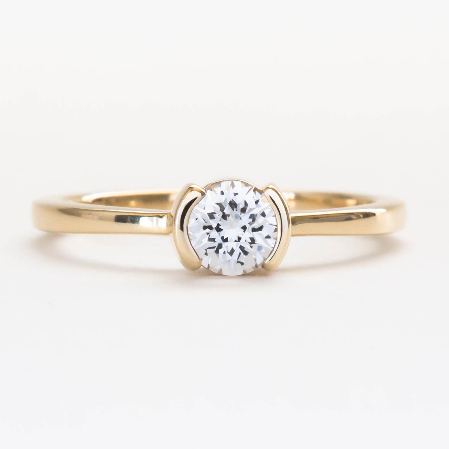Reese half bezel solitaire engagement ring with lab sapphire