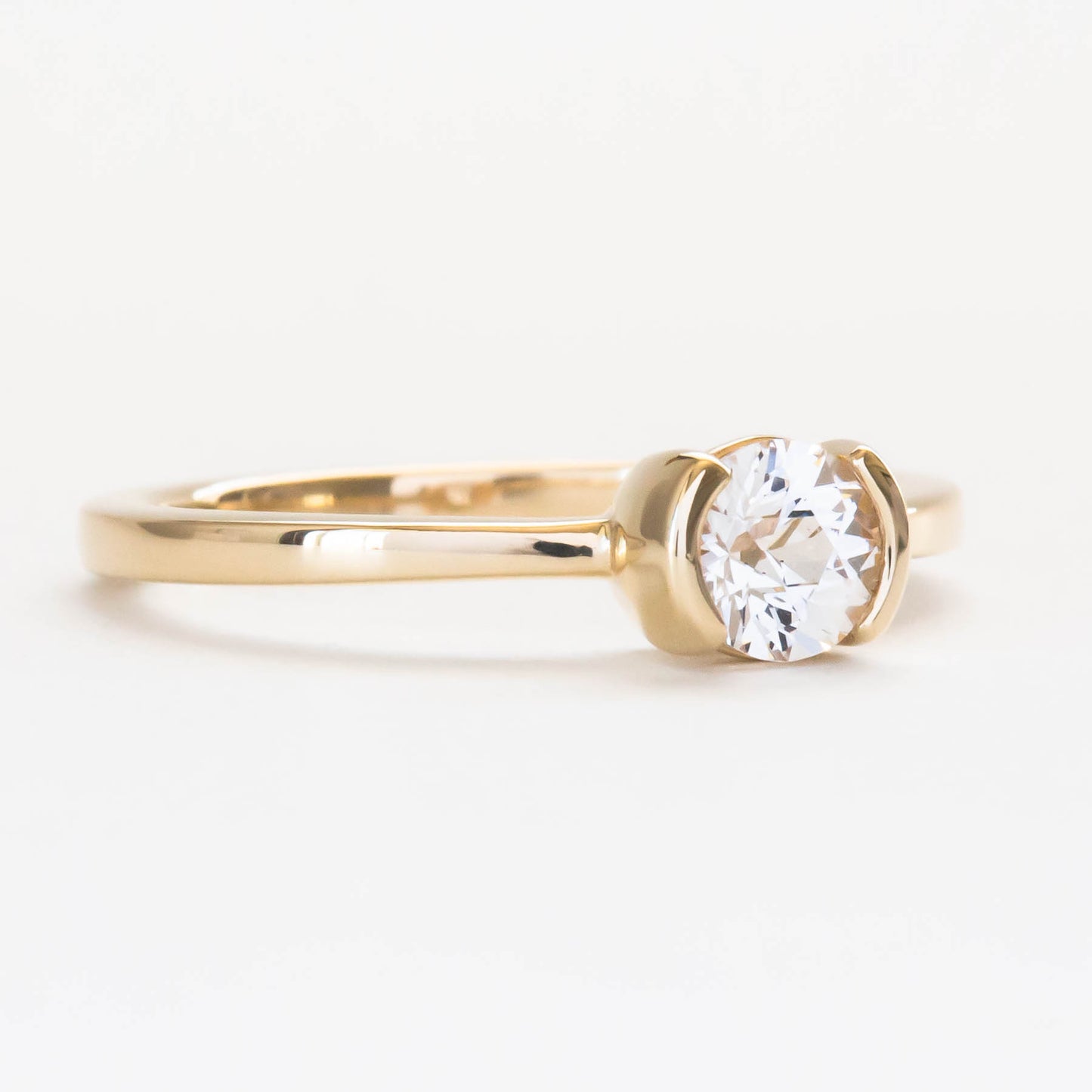 Reese half bezel solitaire engagement ring with lab sapphire