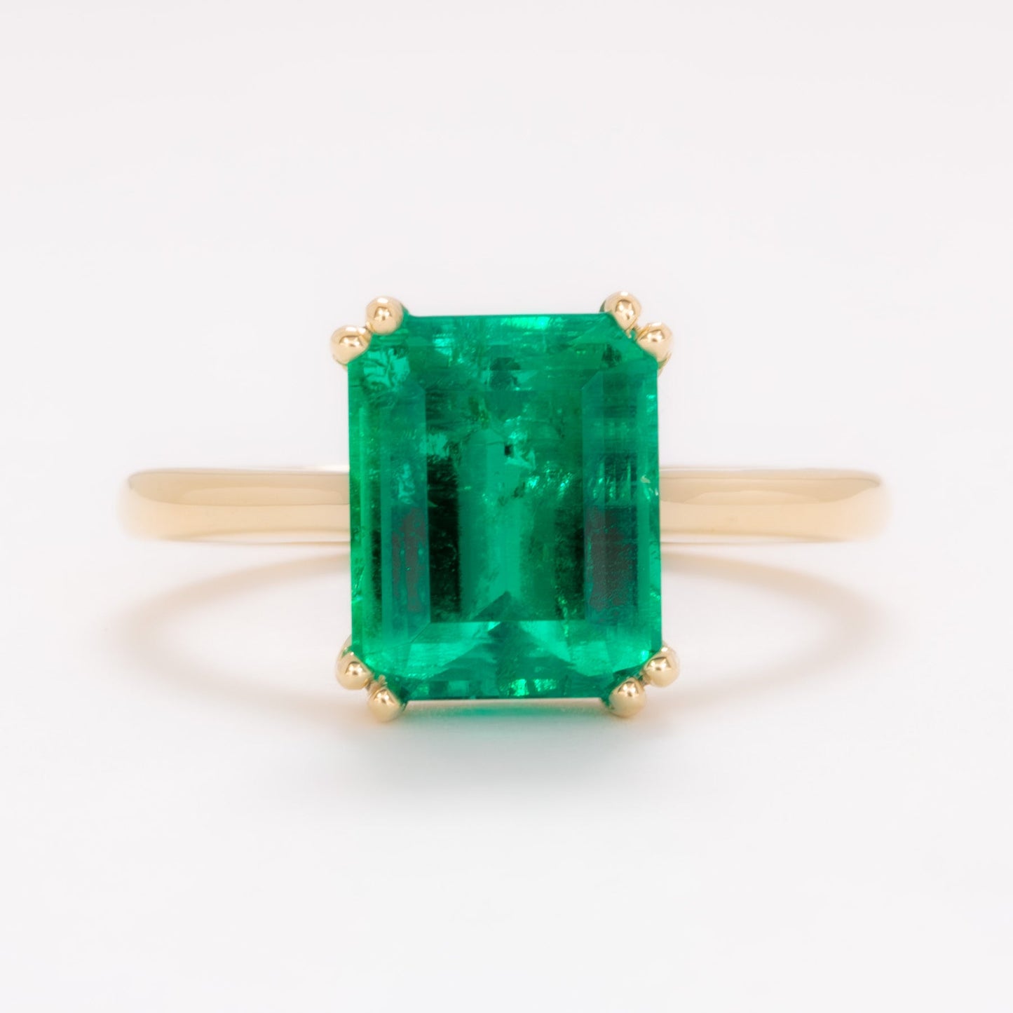 bailey solitaire ring in yellow gold with step cut lab emerald