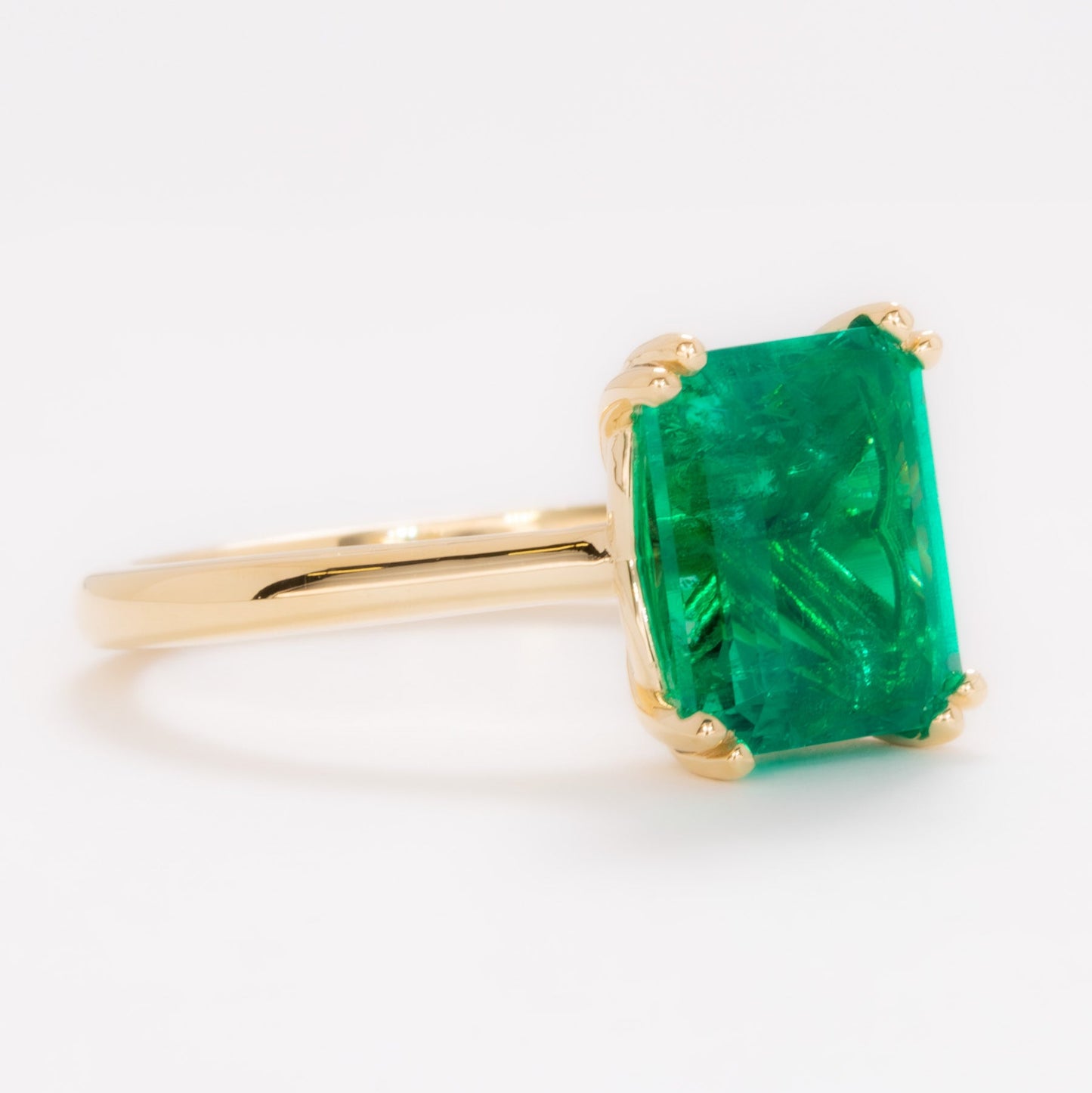 bailey solitaire ring in yellow gold with step cut lab emerald