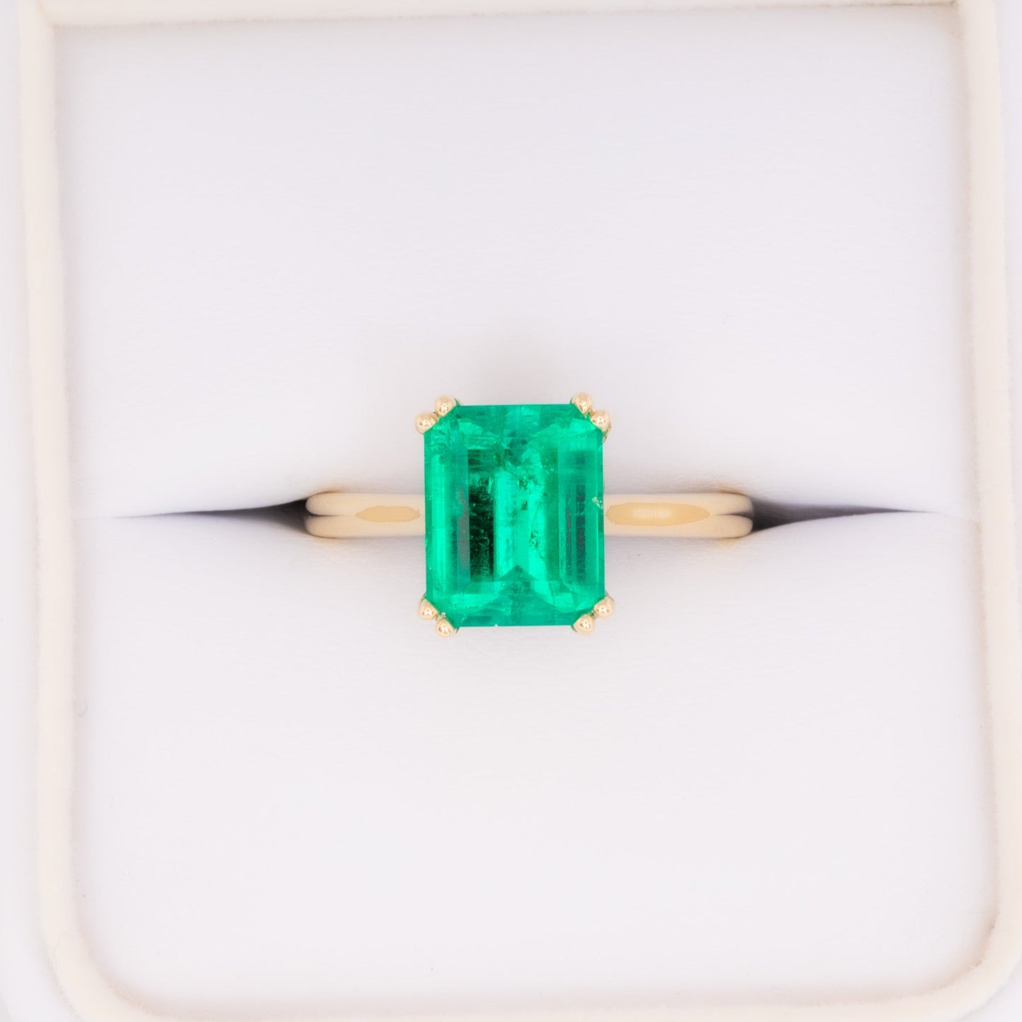 bailey solitaire ring in yellow gold with step cut lab emerald