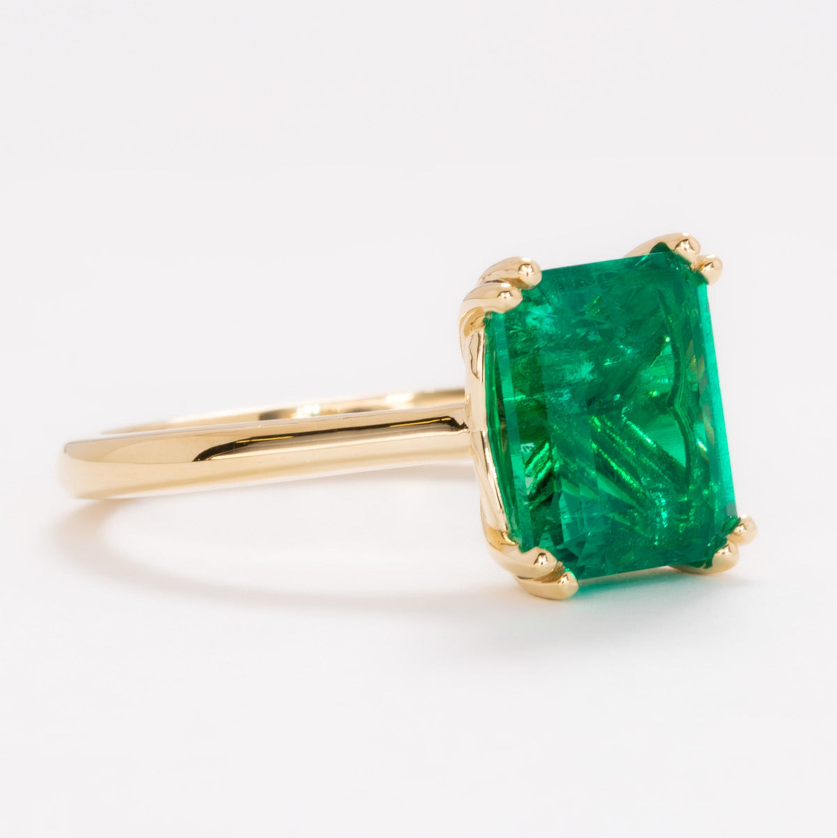 bailey solitaire ring in yellow gold with step cut lab emerald