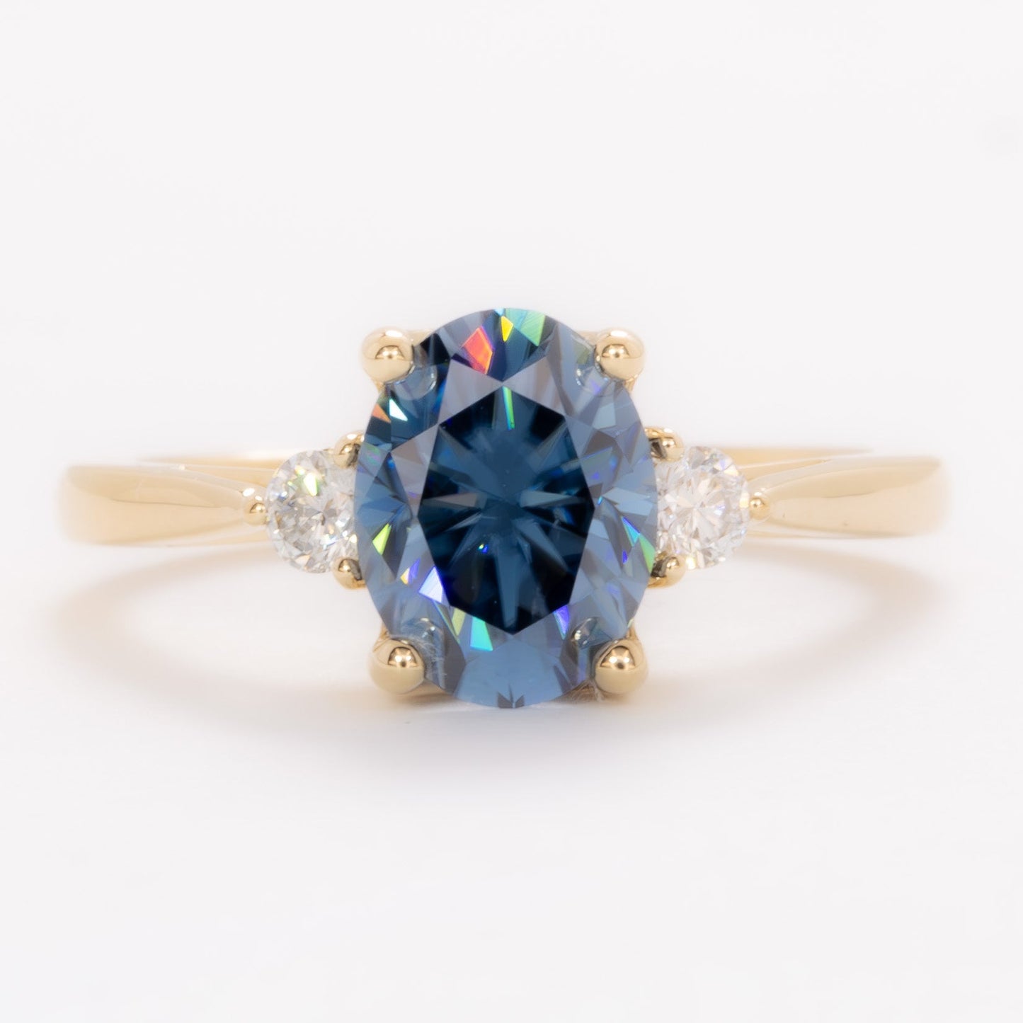 carina three stone ring with blue moissanite oval