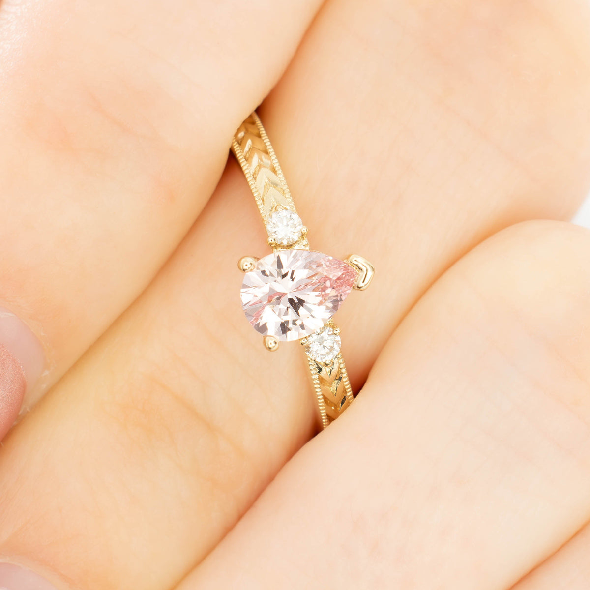 meera three stone ring with chevron detail in yellow gold and pink lab sapphire pear