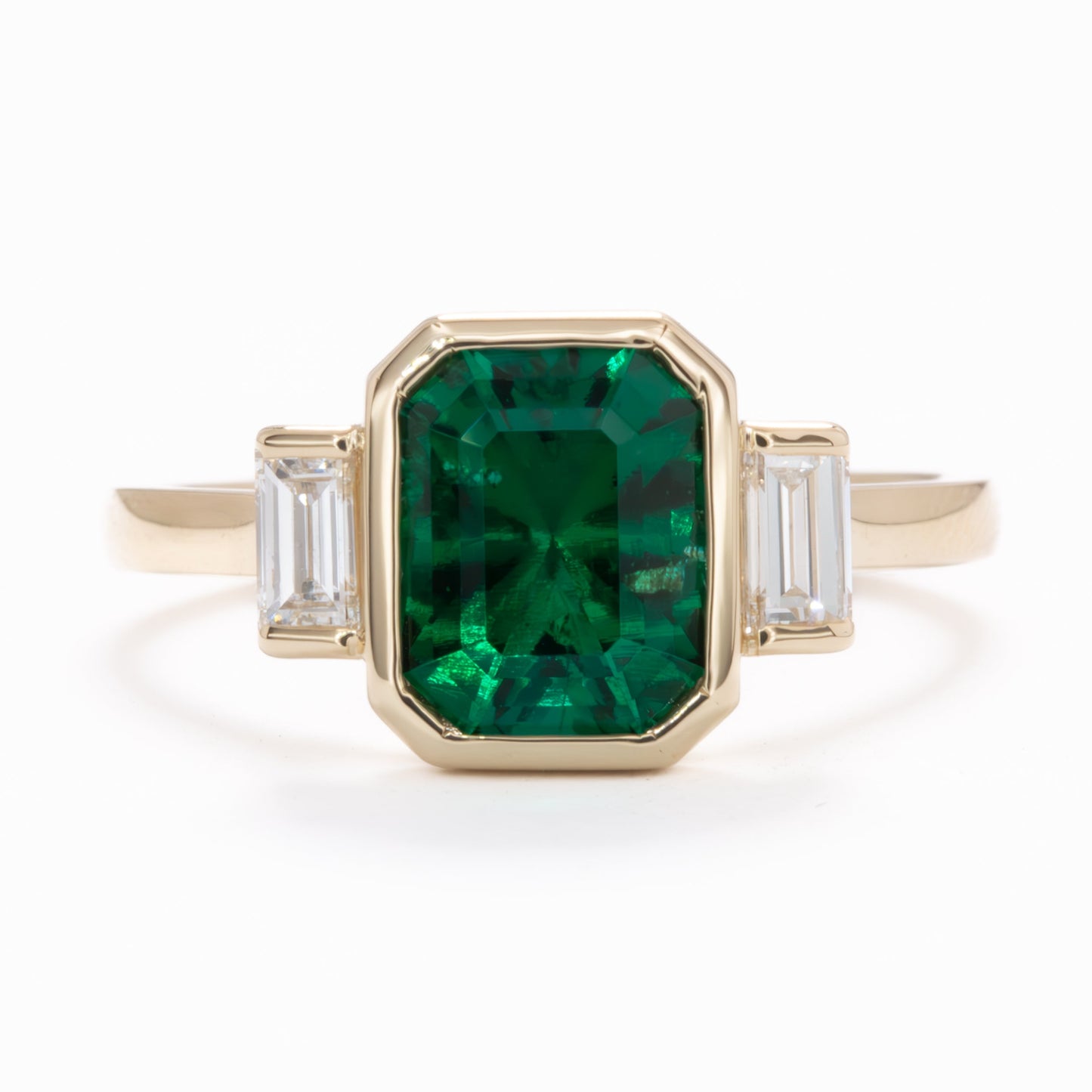 scottie three stone bezel set engagement ring with lab emerald