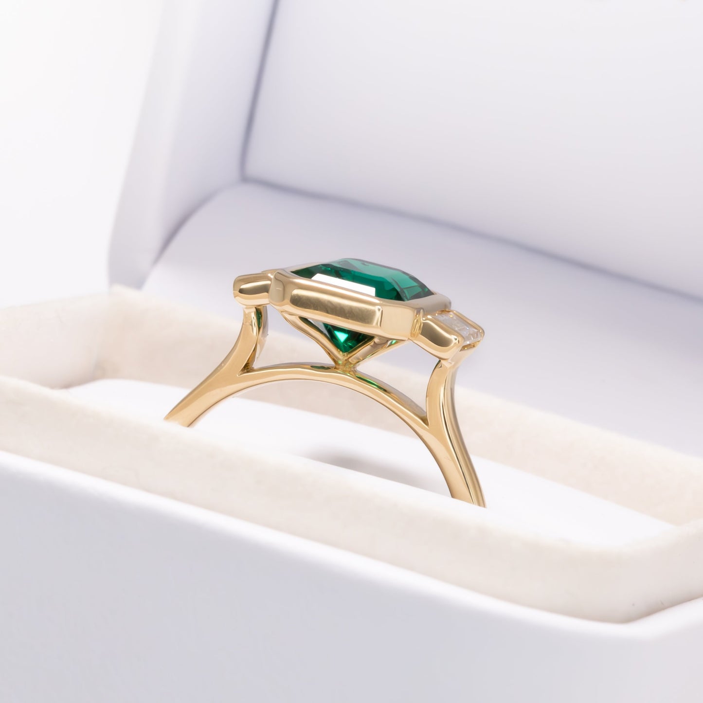 scottie three stone bezel set engagement ring with lab emerald