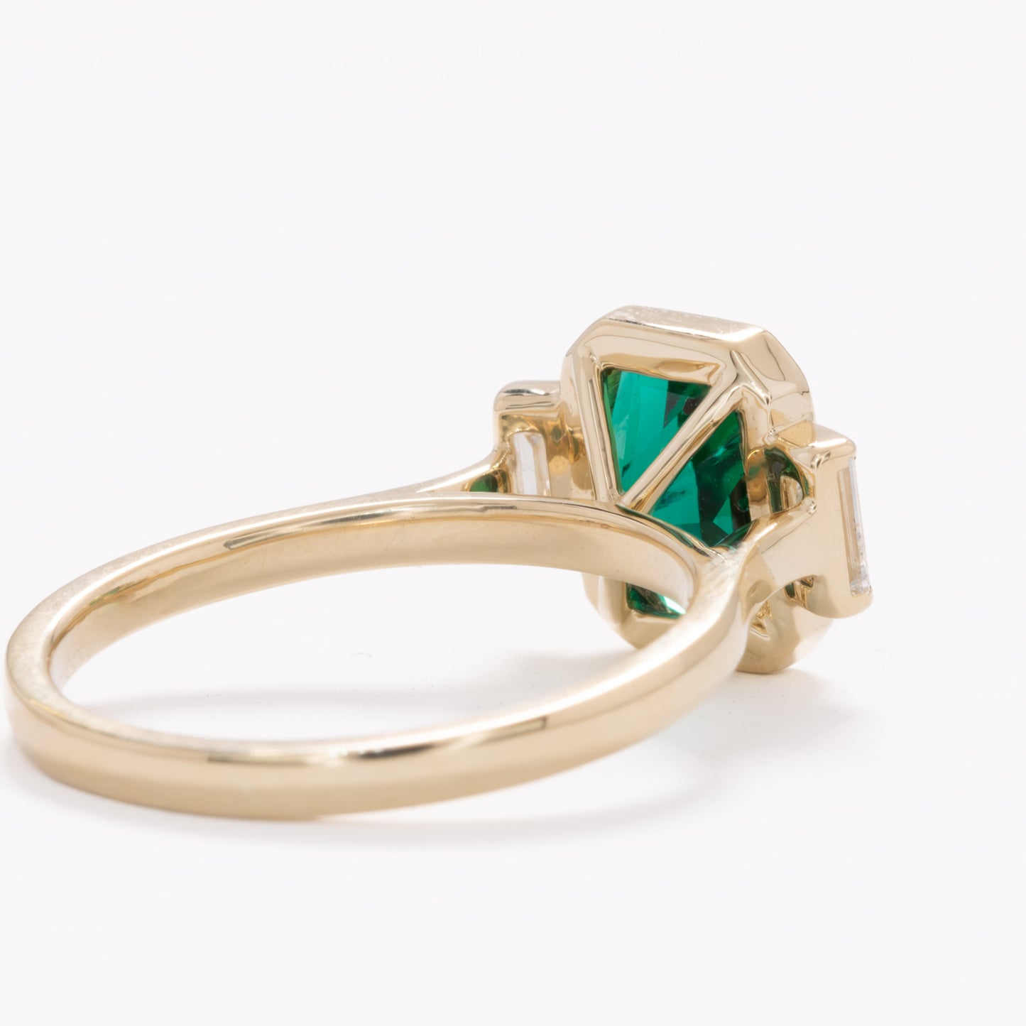 scottie three stone bezel set engagement ring with lab emerald