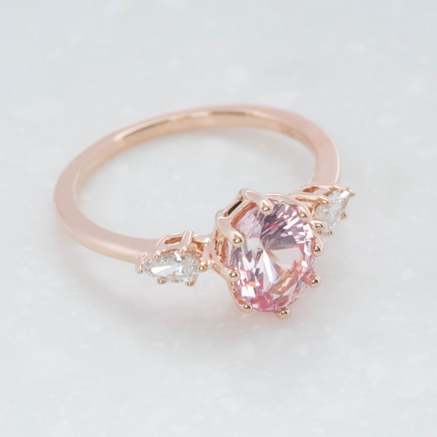 three stone engagement ring with peach oval lab sapphire