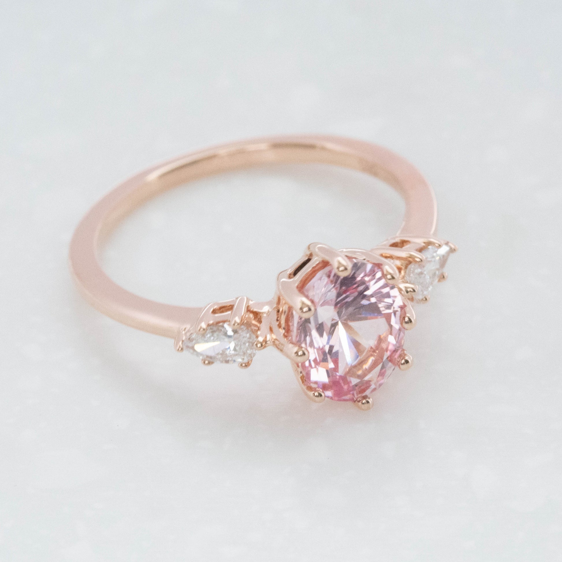 three stone engagement ring with peach oval lab sapphire