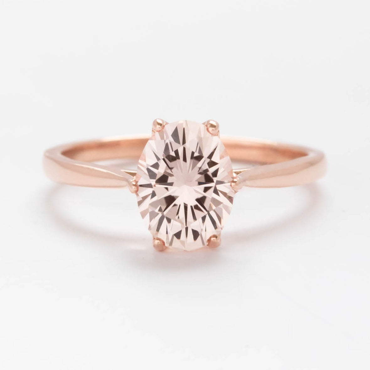 Daphnis solitaire engagement ring with oval peach lab sapphire