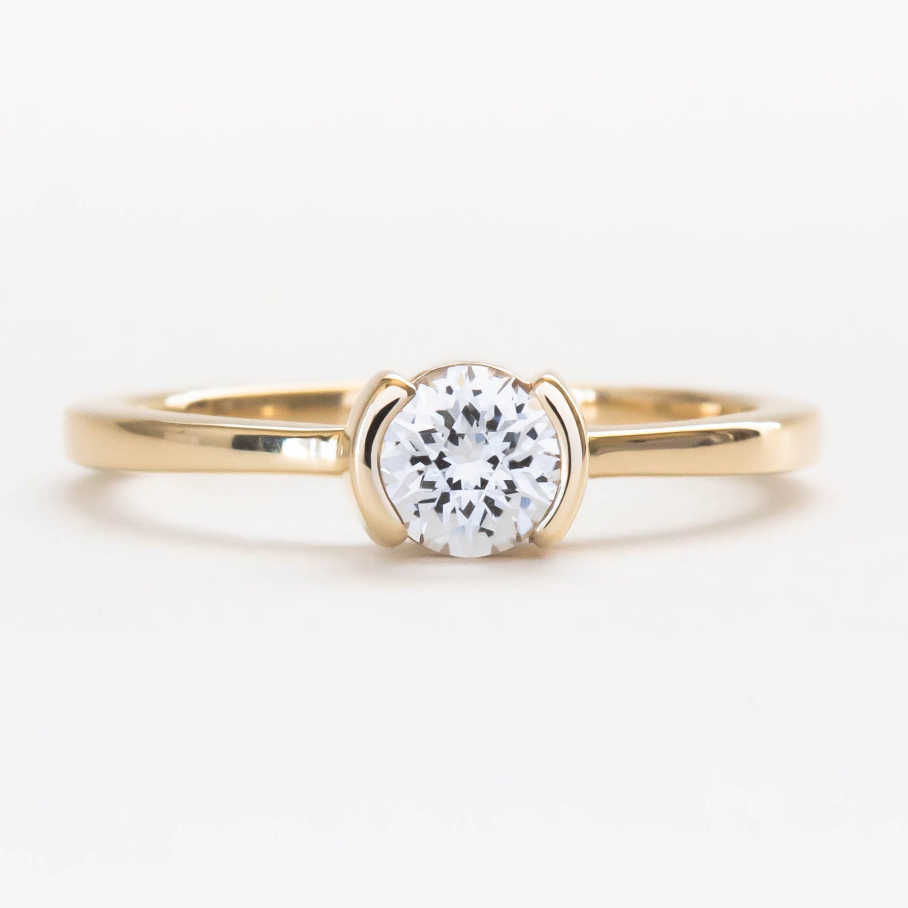 Reese half bezel solitaire engagement ring with lab sapphire
