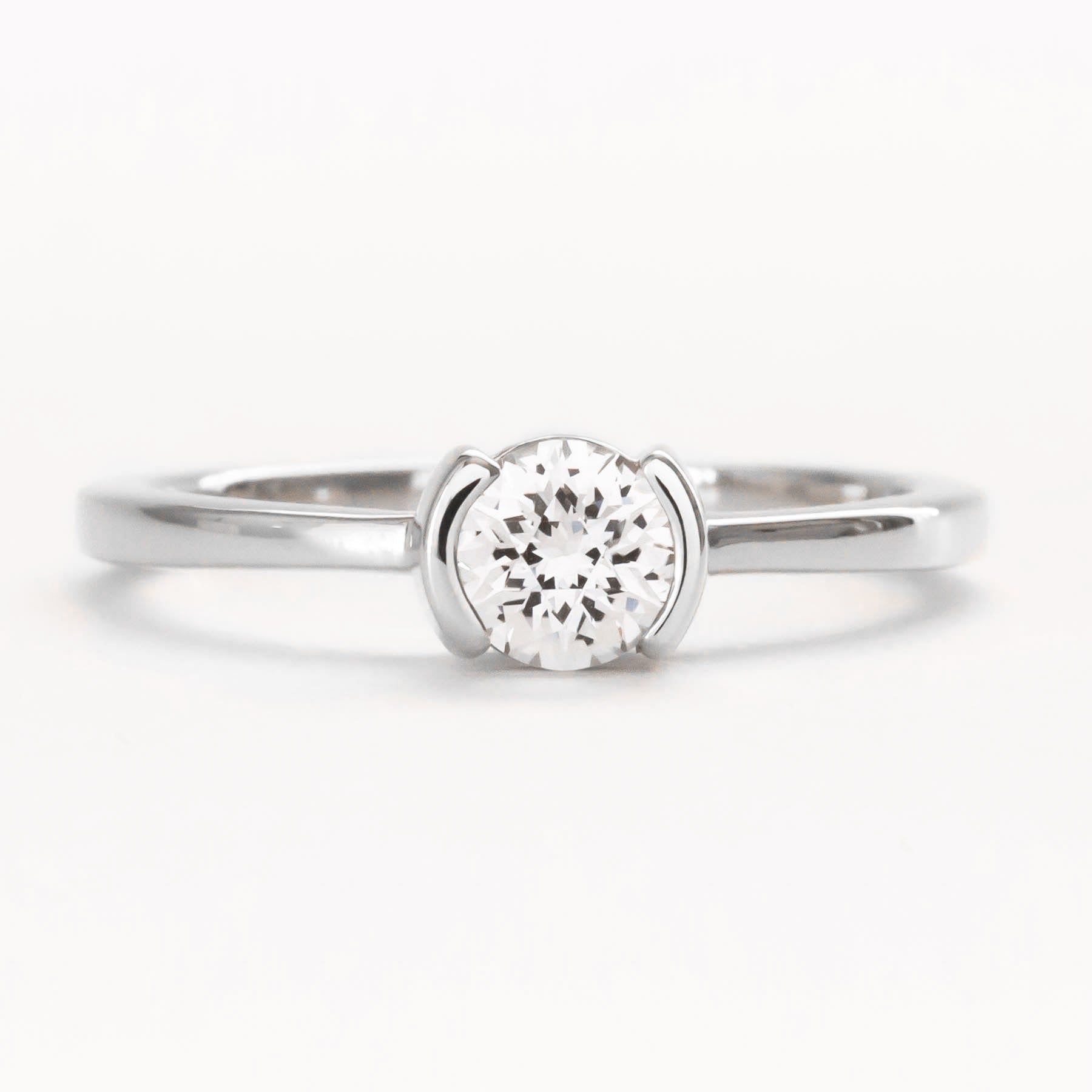Reese half bezel solitaire engagement ring with lab sapphire