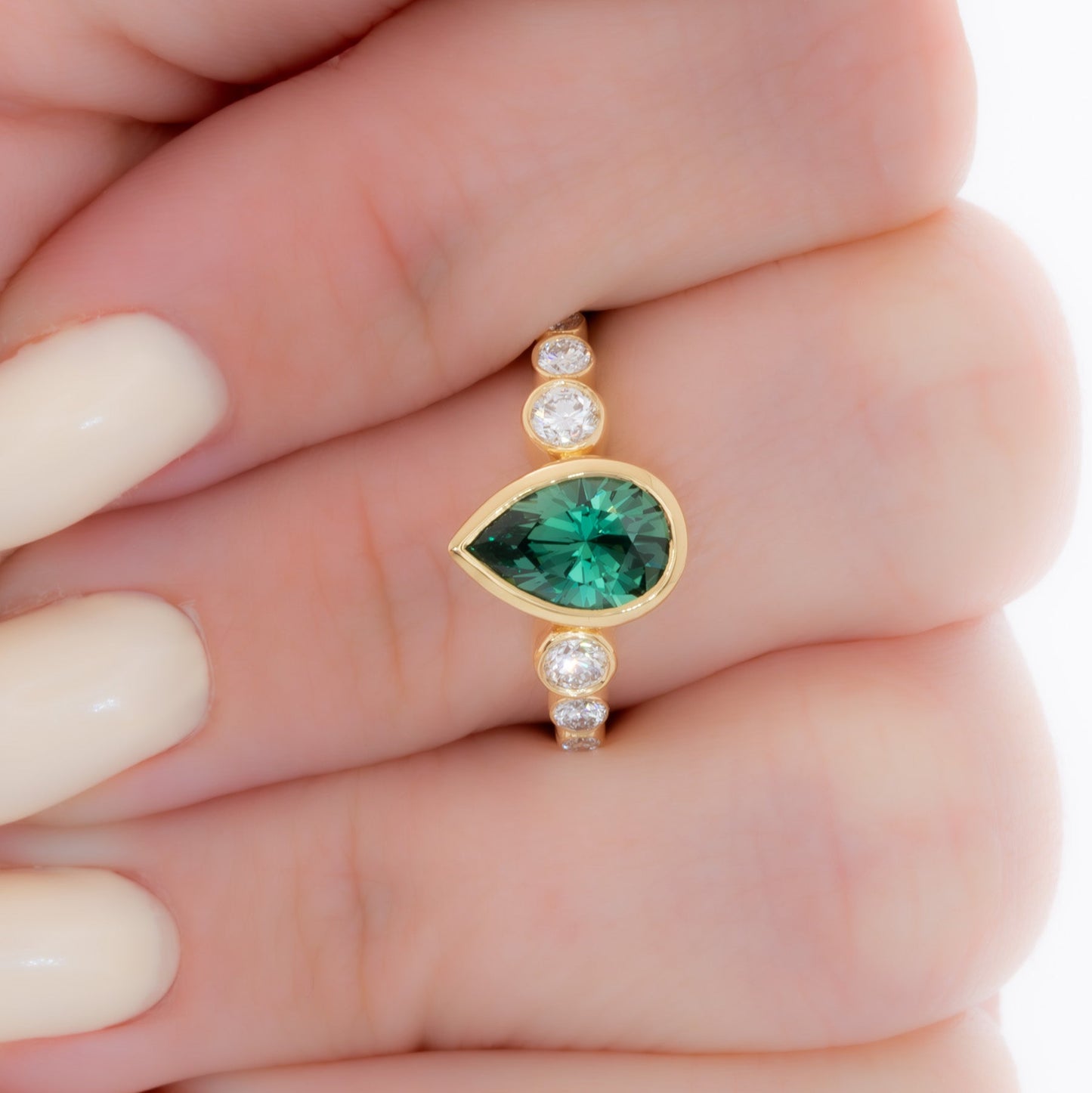aisha bezel set ring with green lab sapphire pear