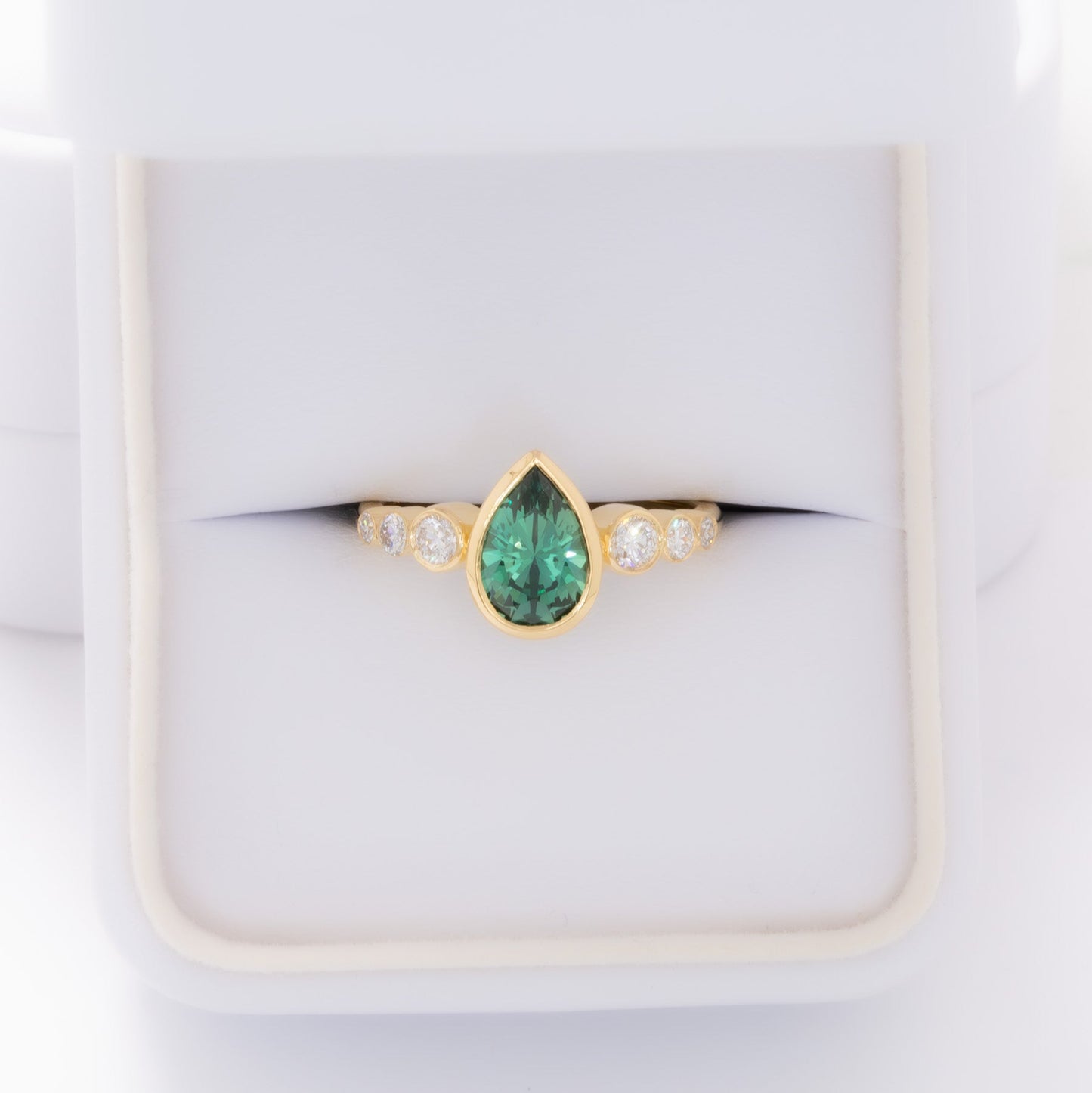 aisha bezel set ring with green lab sapphire pear