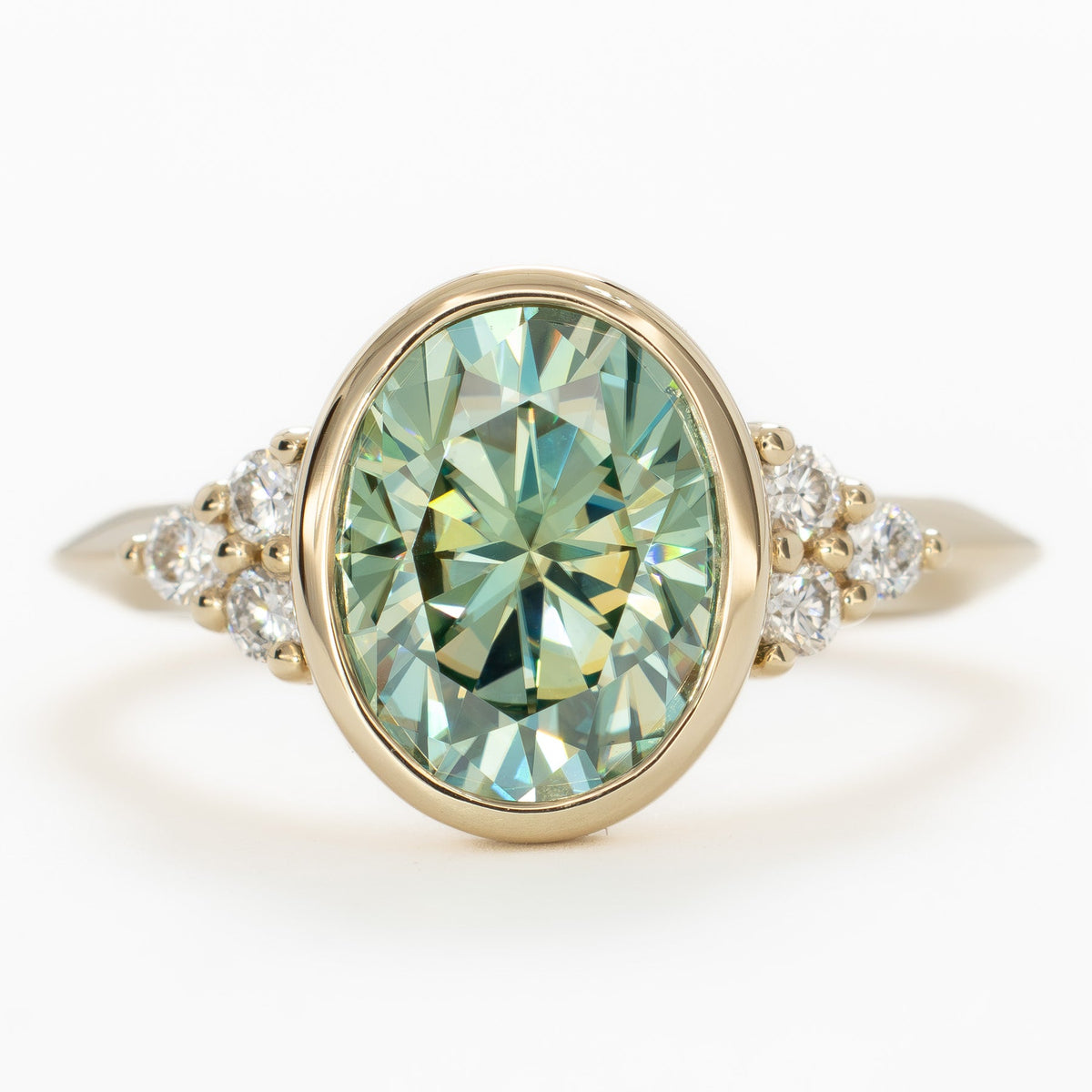 alinta bezel set accented ring in yellow gold with green moissanite oval