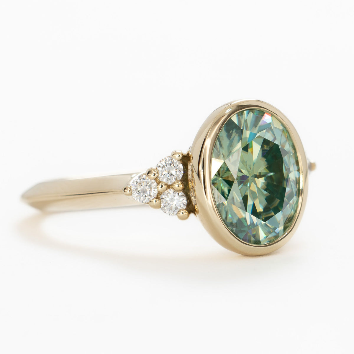 alinta bezel set accented ring in yellow gold with green moissanite oval