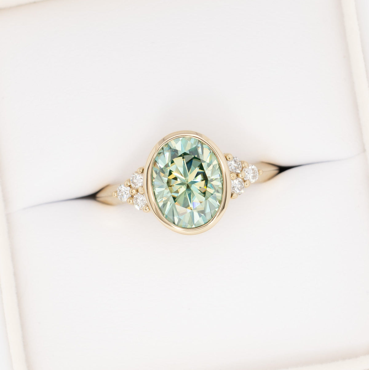 alinta bezel set accented ring in yellow gold with green moissanite oval
