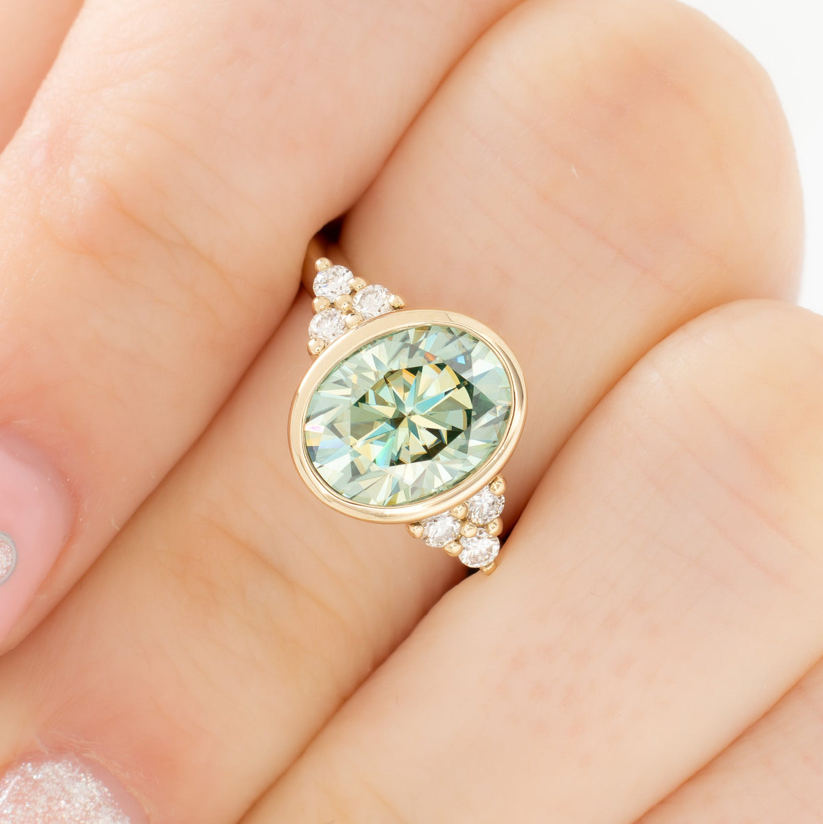 alinta bezel set accented ring in yellow gold with green moissanite oval