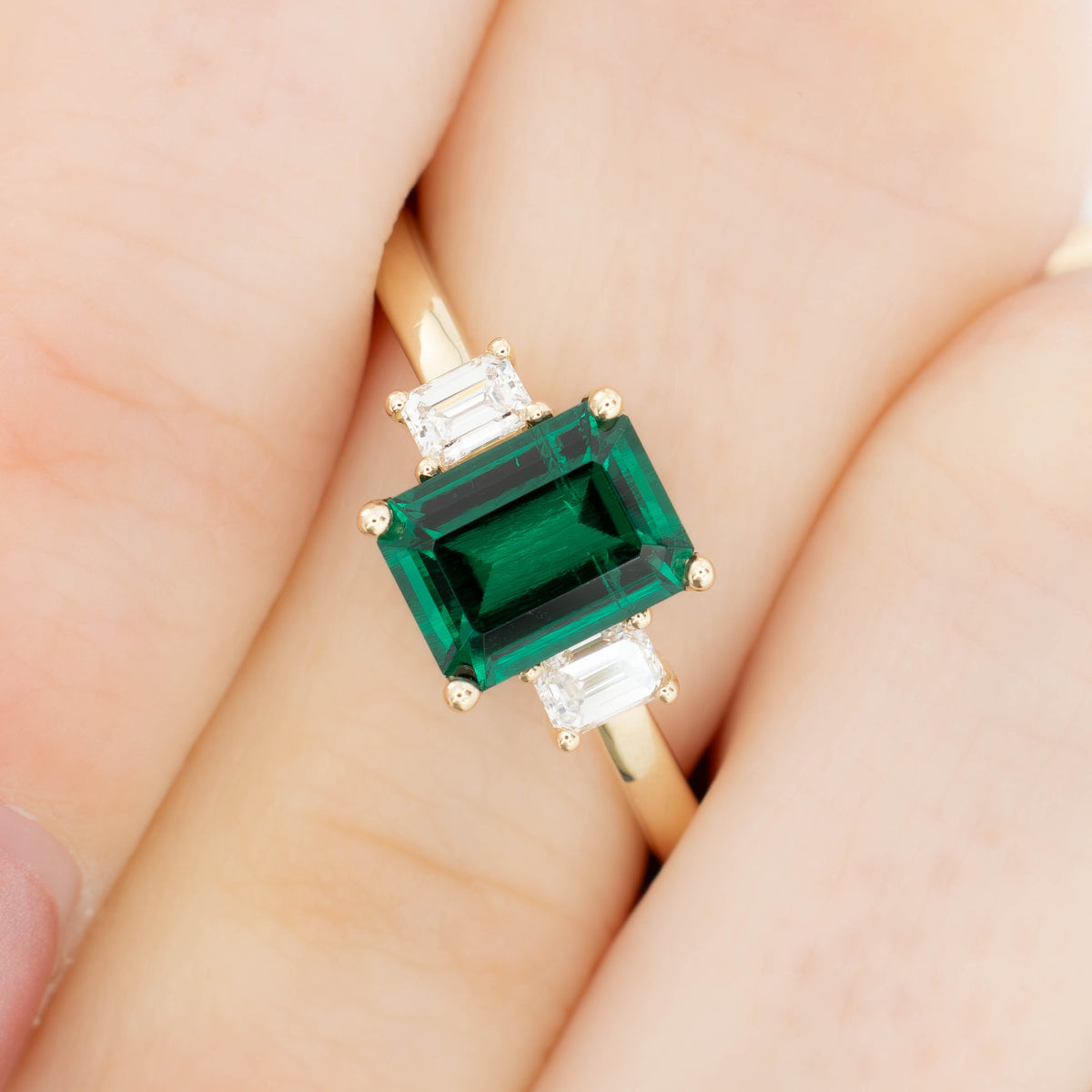 ami three stone ring in yellow gold with step cut lab emerald