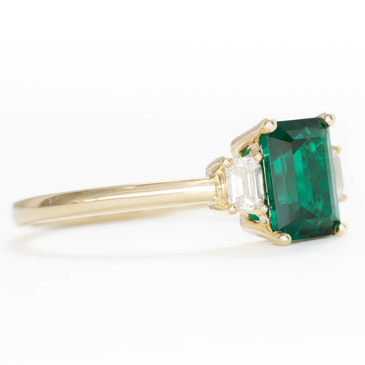 ami three stone ring in yellow gold with step cut lab emerald