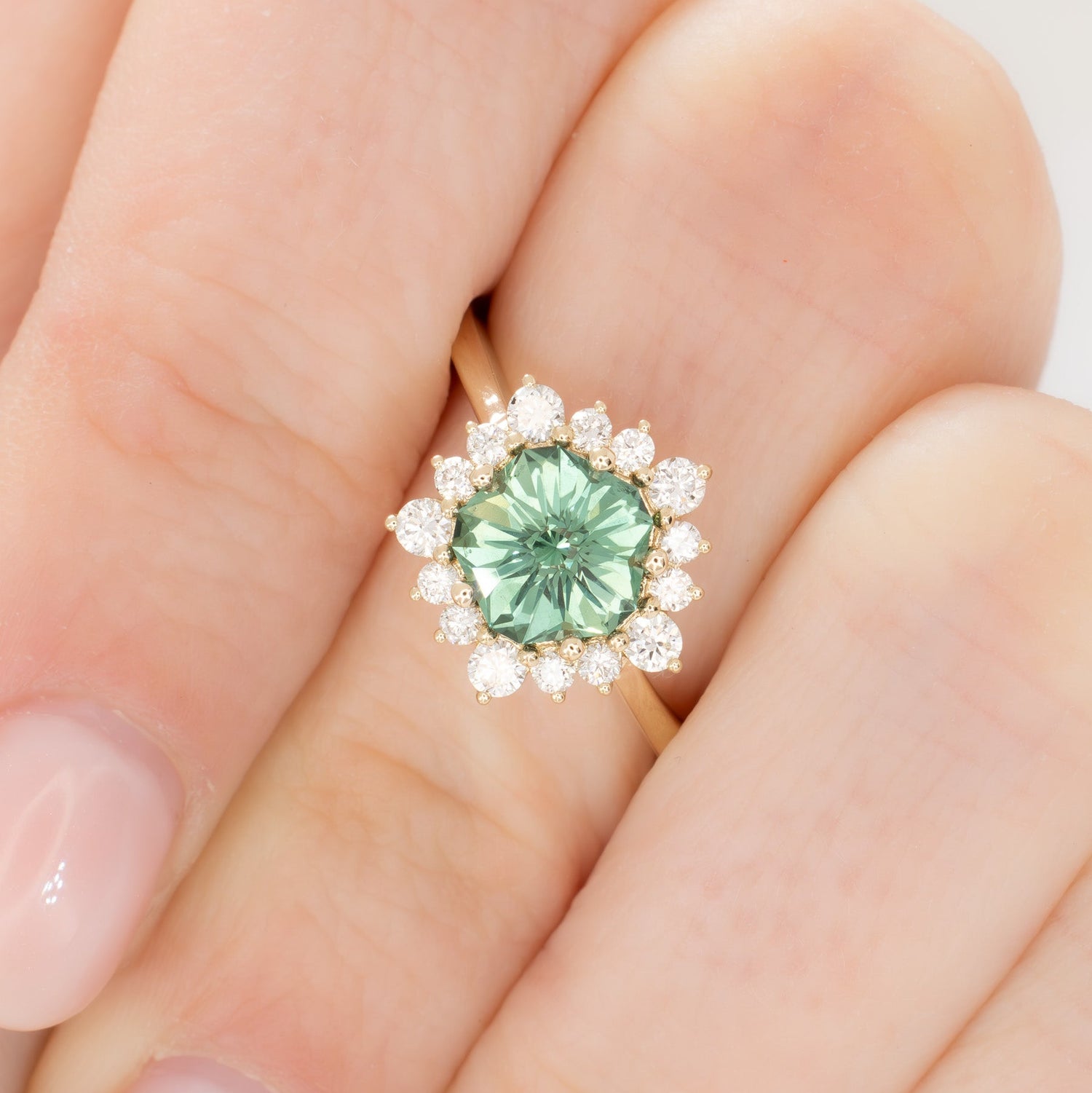 aurora snowflake inspired halo engagement ring with a green lab sapphire hanami pentagon