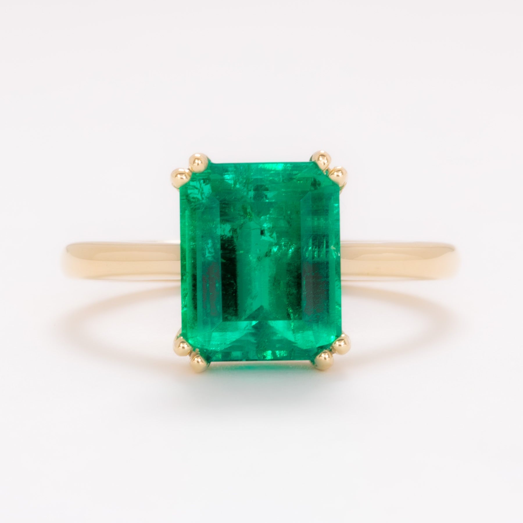 bailey solitaire ring in yellow gold with step cut lab emerald