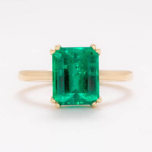 bailey solitaire ring in yellow gold with step cut lab emerald