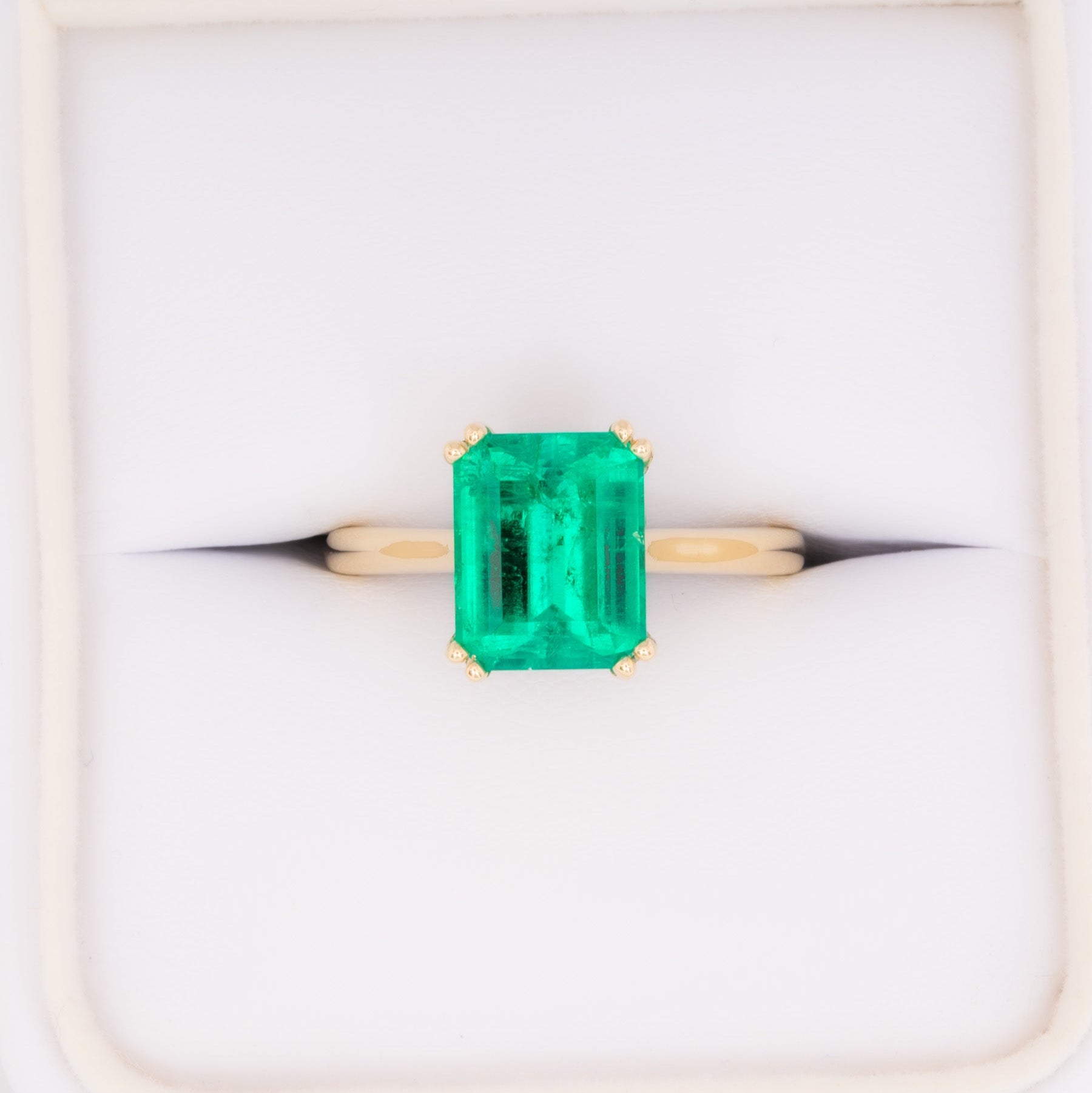 bailey solitaire ring in yellow gold with step cut lab emerald