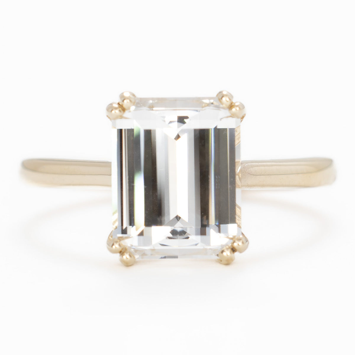 bailey solitaire ring in yellow gold with step cut white lab sapphire