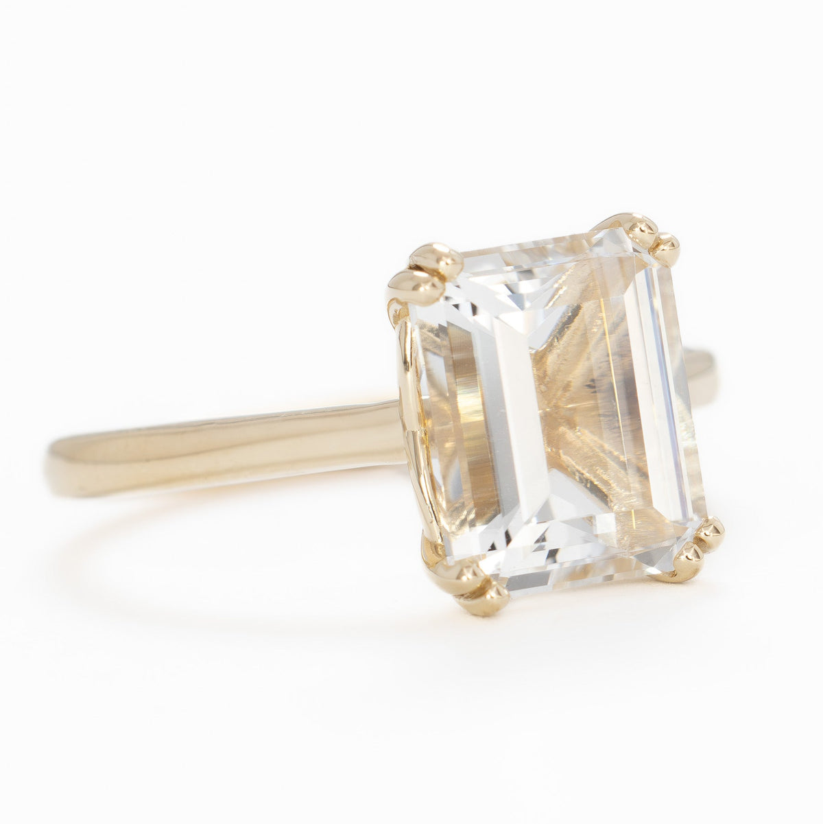 bailey solitaire ring in yellow gold with step cut white lab sapphire