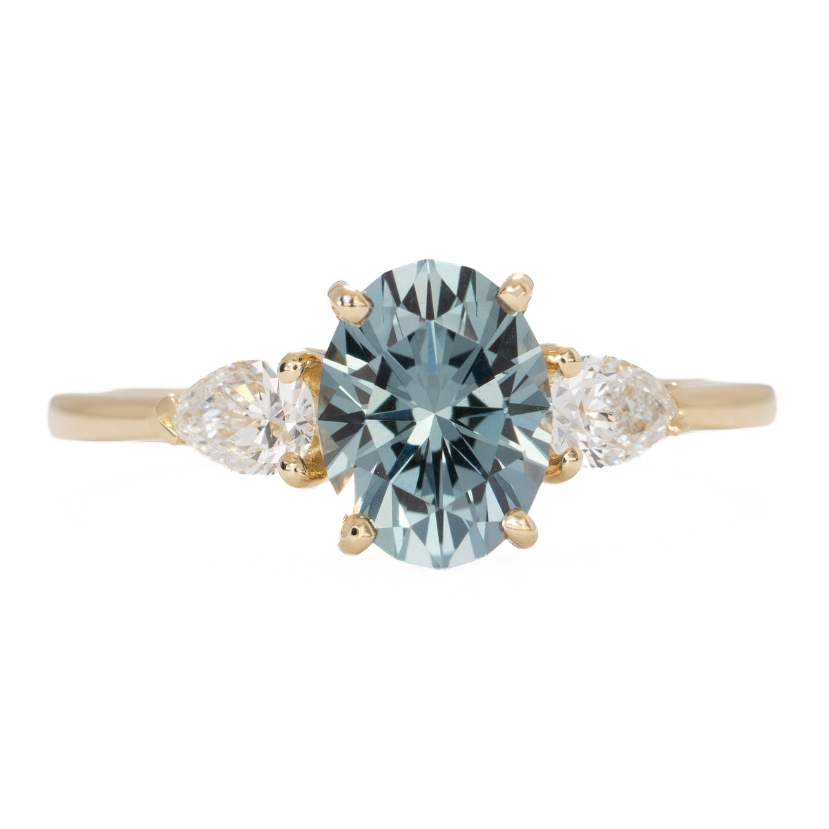 beckett three stone ring in yellow gold with oval blue-green lab sapphire
