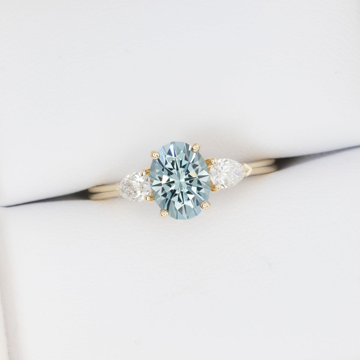 beckett three stone ring in yellow gold with oval blue-green lab sapphire