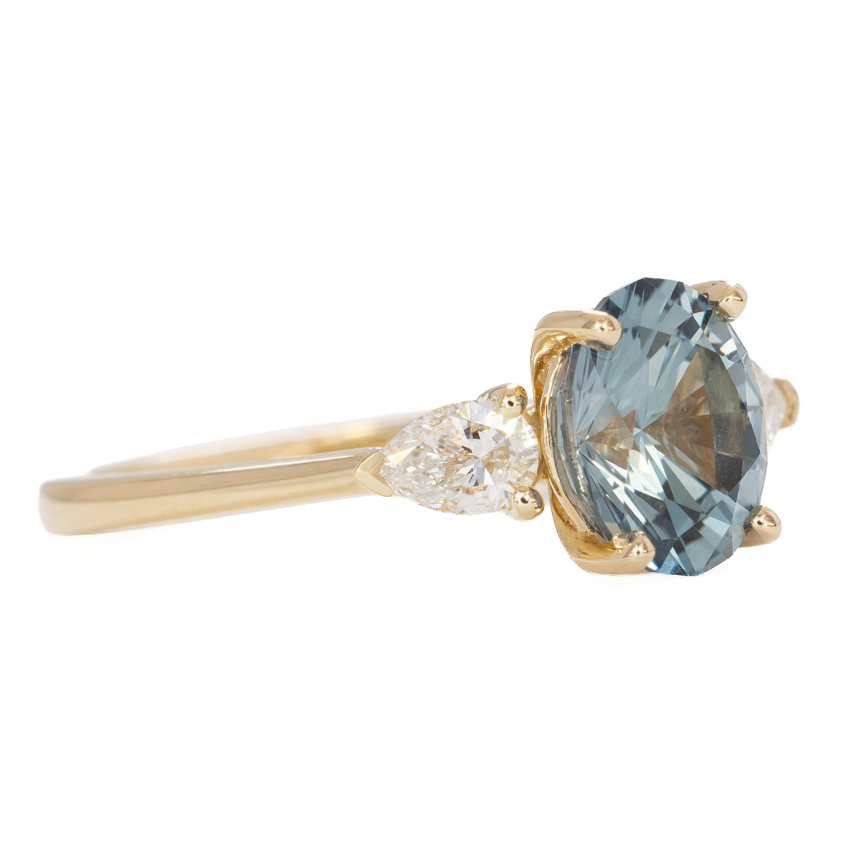 beckett three stone ring in yellow gold with oval blue-green lab sapphire