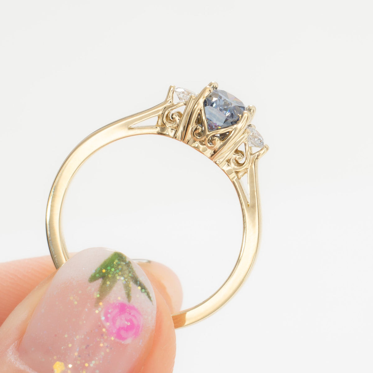 carina three stone ring in yellow gold with oval blue moissanite
