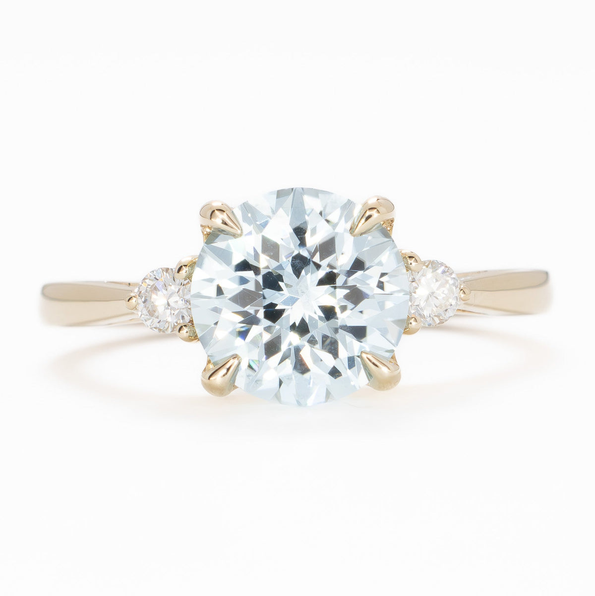 carina three stone ring in yellow gold with round light blue lab sapphire