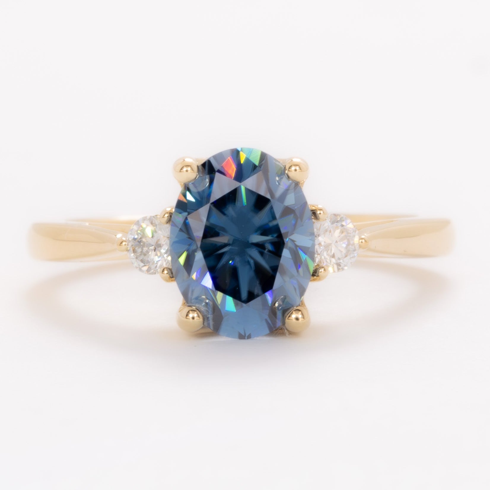 carina three stone ring with blue moissanite oval