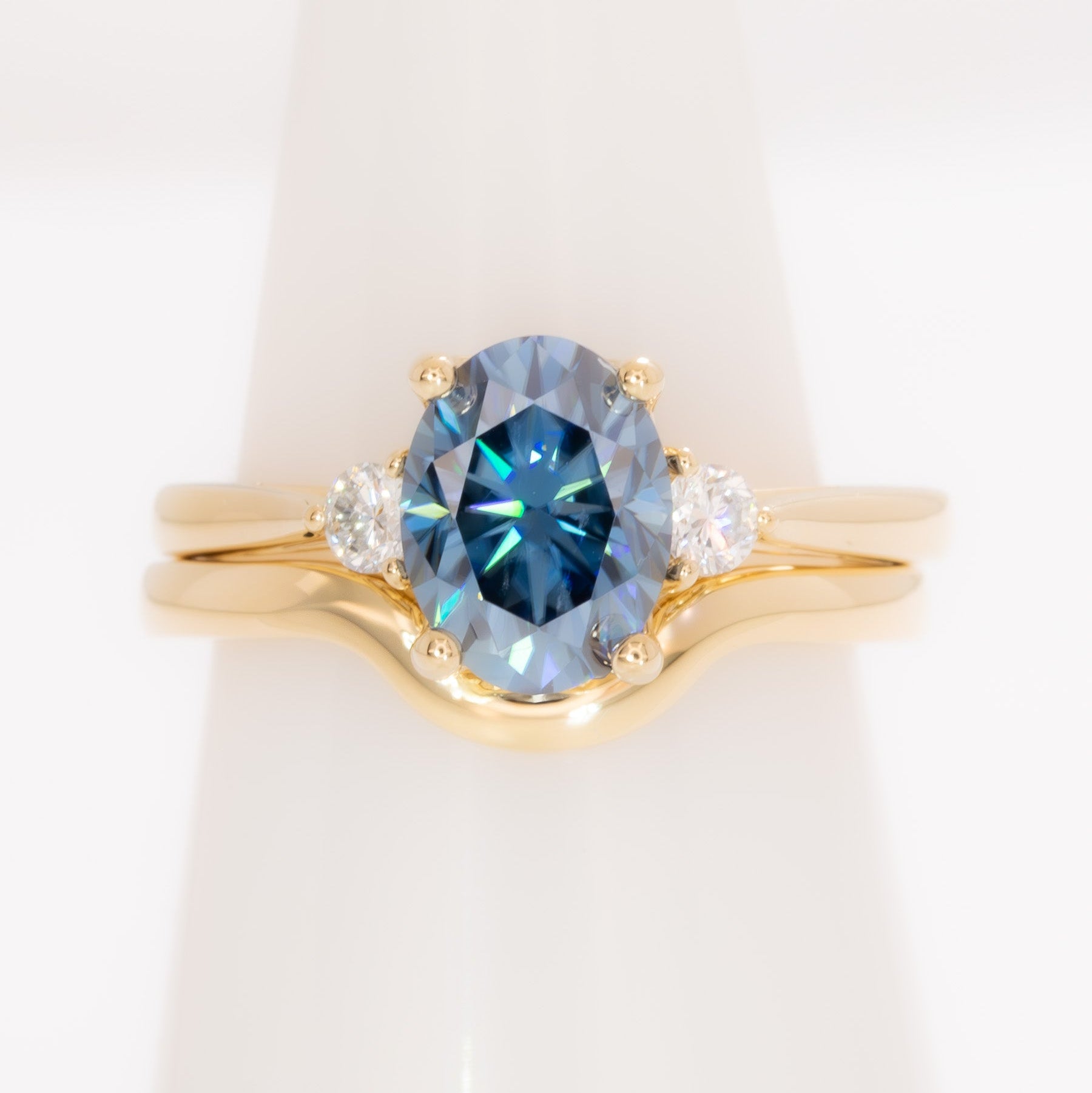 carina three stone ring with blue moissanite oval