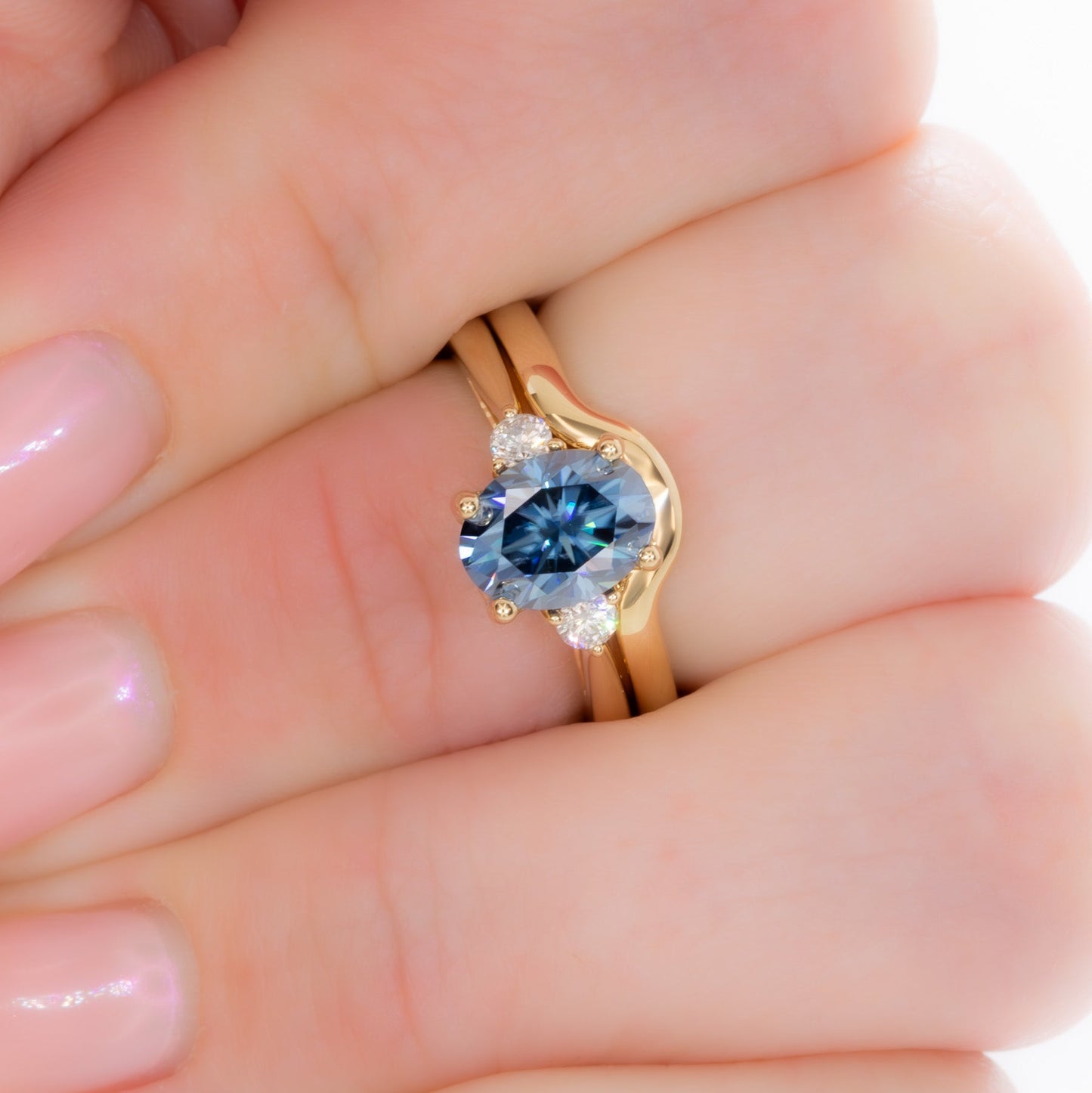 carina three stone ring with blue moissanite oval