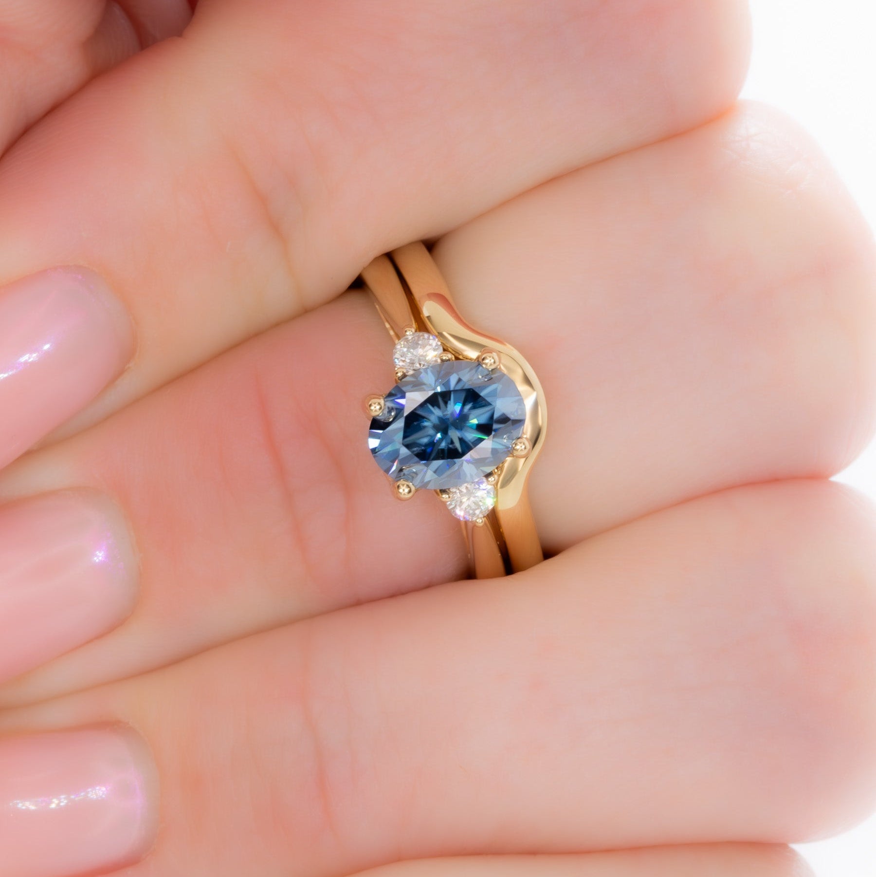 carina three stone ring with blue moissanite oval