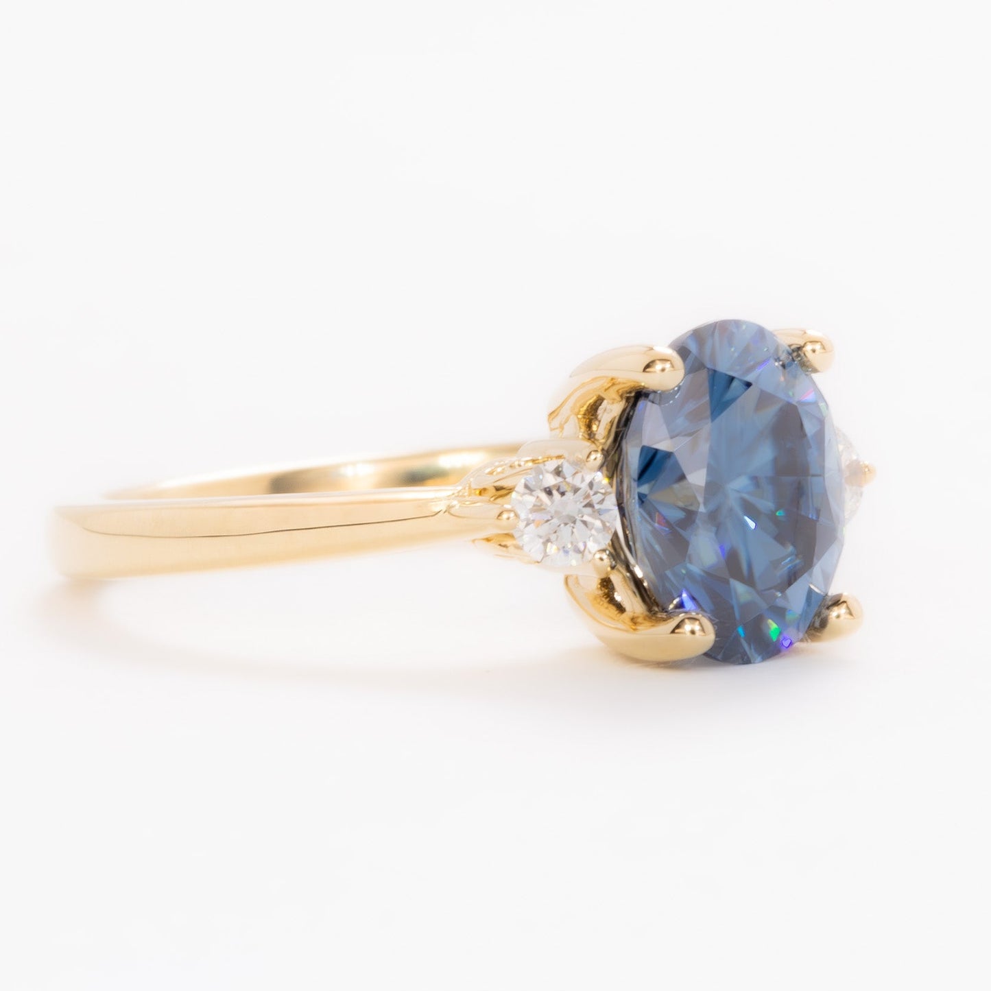 carina three stone ring with blue moissanite oval