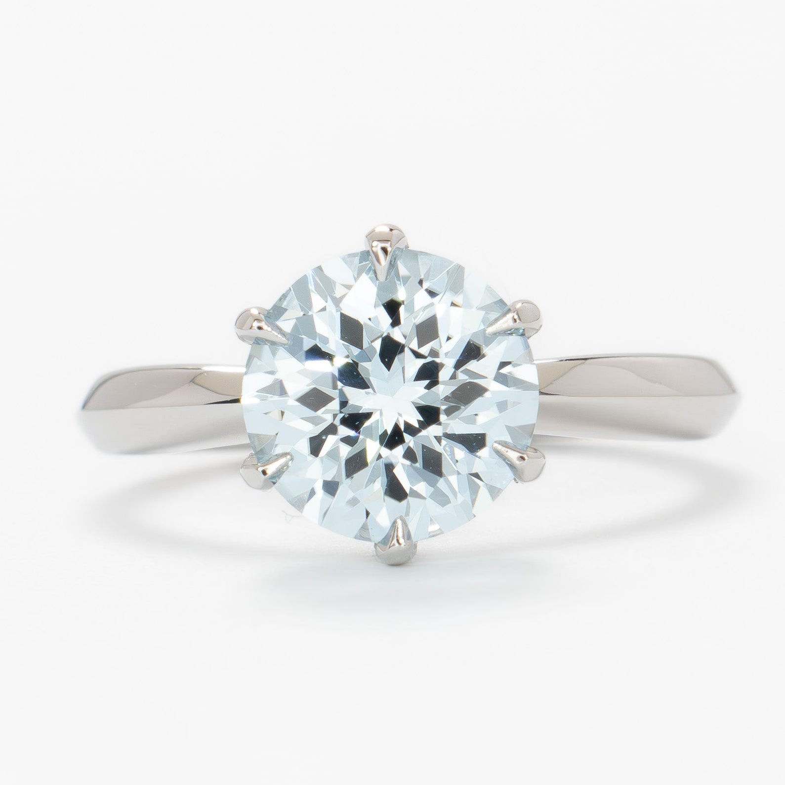charlotte solitaire engagement ring with round light blue lab sapphire