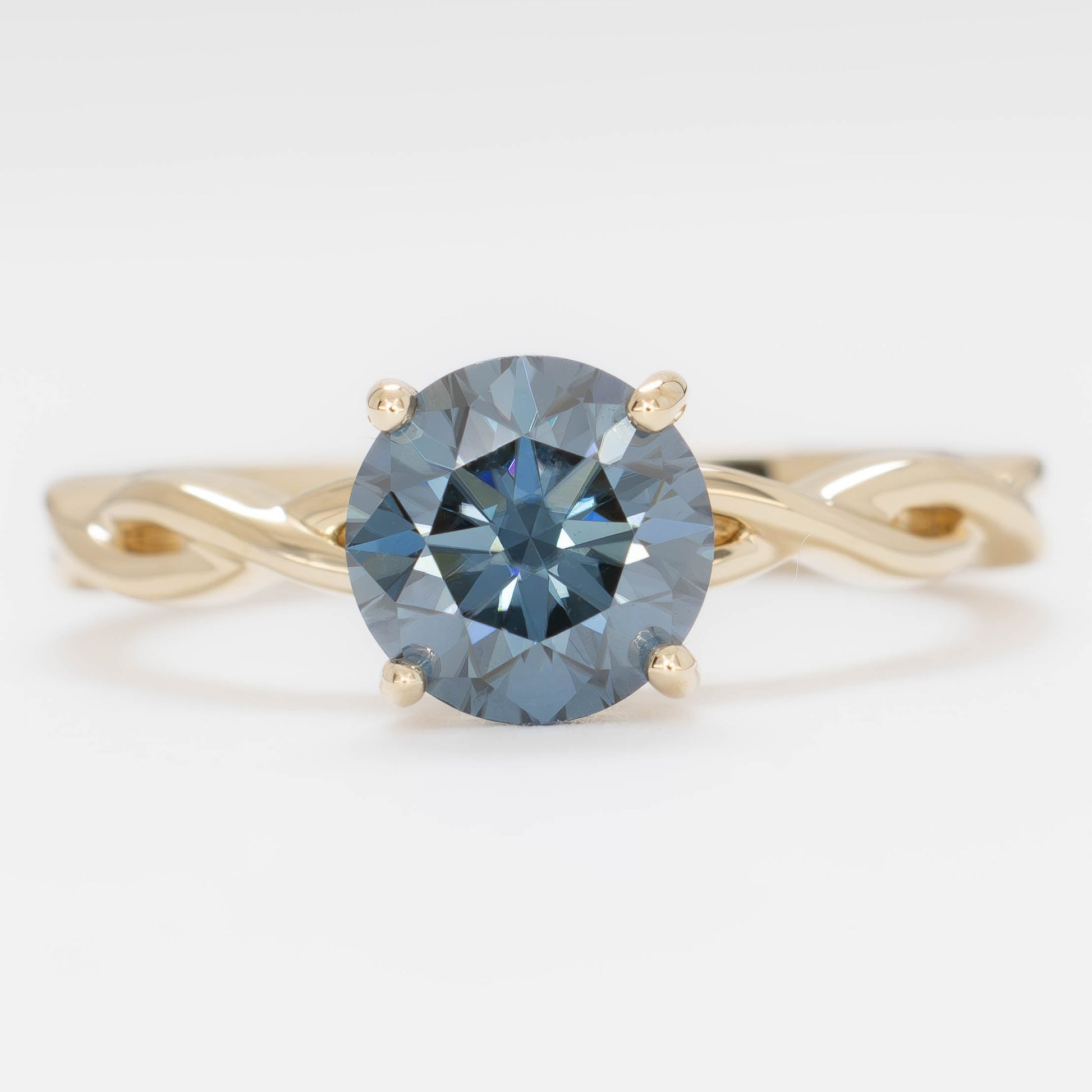 cressida solitaire engagement ring in yellow gold with blue moissanite round brilliant
