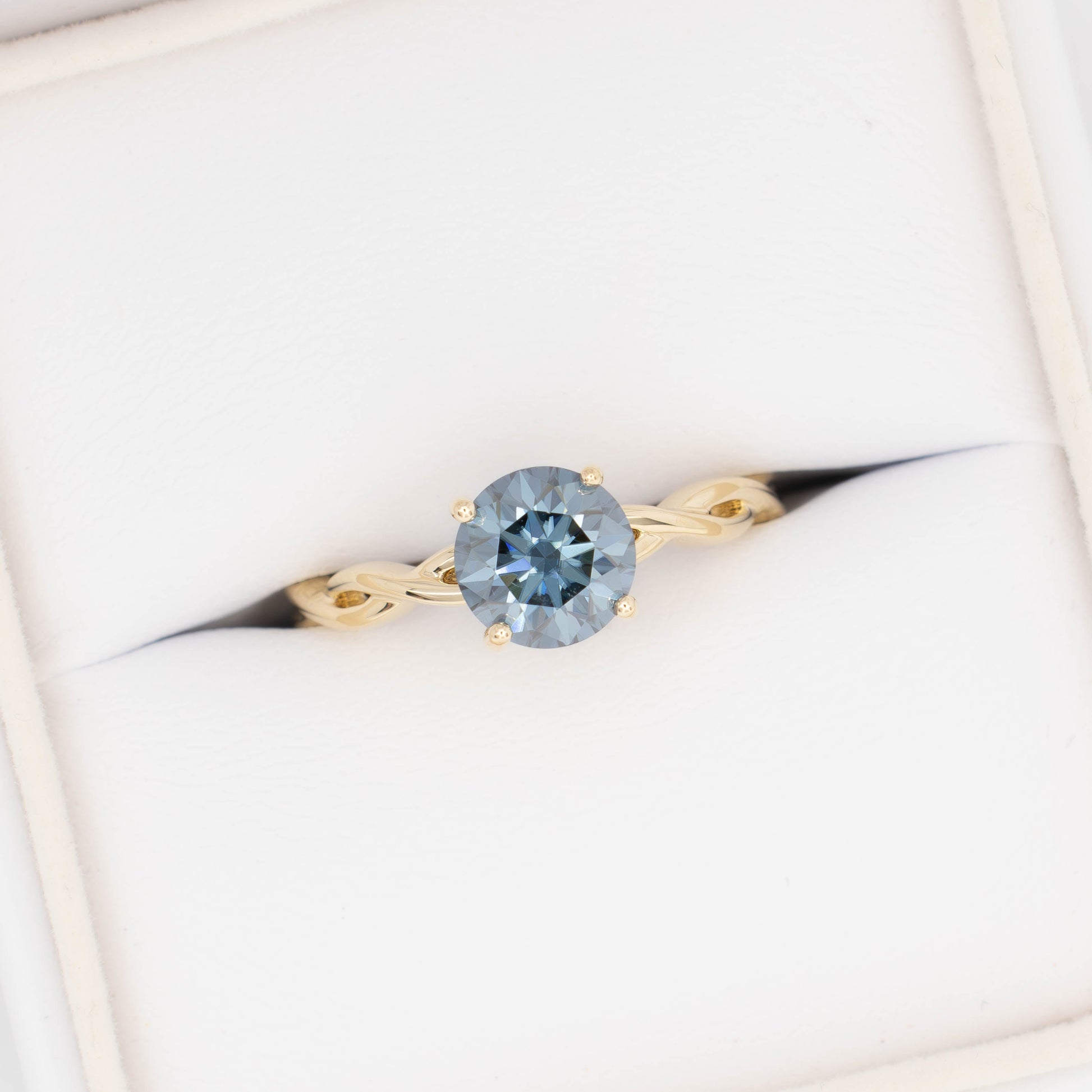 cressida solitaire engagement ring in yellow gold with blue moissanite round brilliant