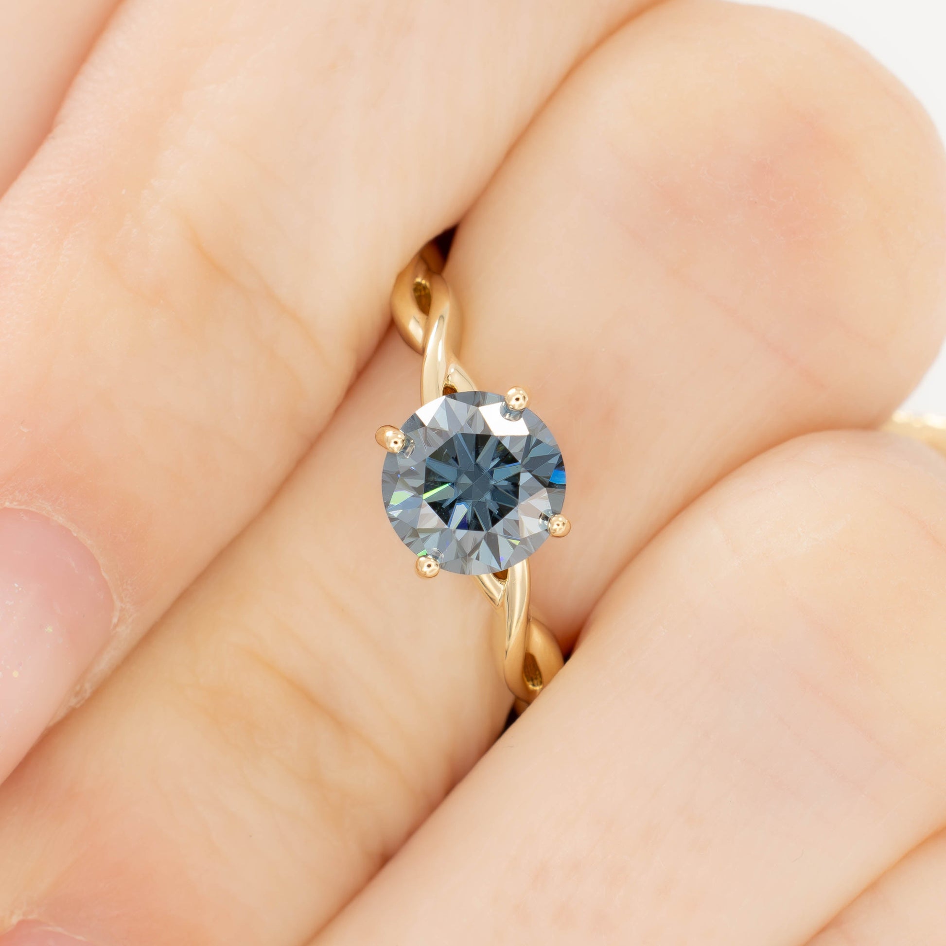 cressida solitaire engagement ring in yellow gold with blue moissanite round brilliant