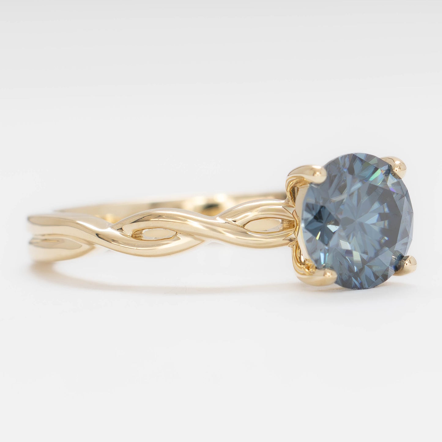 cressida solitaire engagement ring in yellow gold with blue moissanite round brilliant
