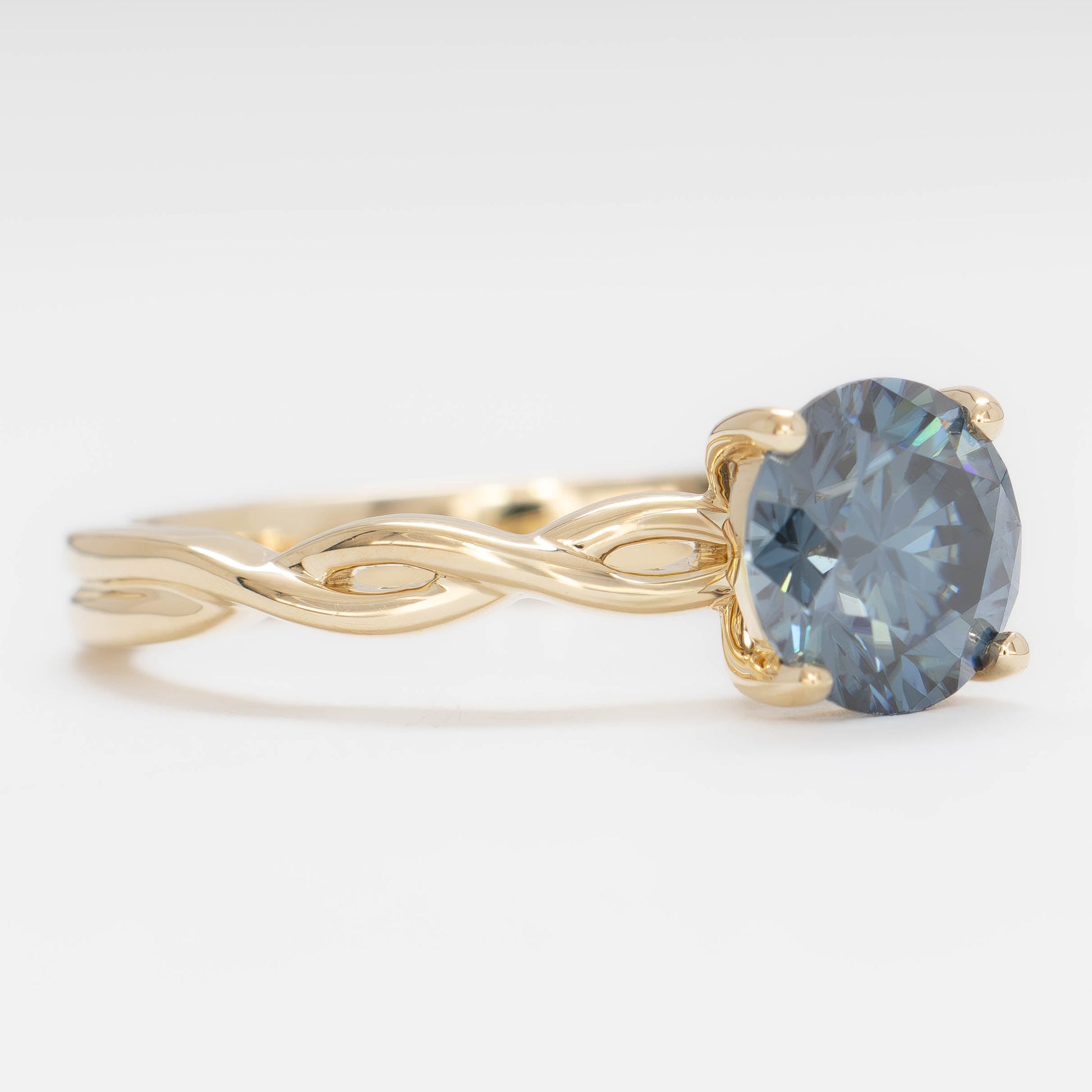 cressida solitaire engagement ring in yellow gold with blue moissanite round brilliant