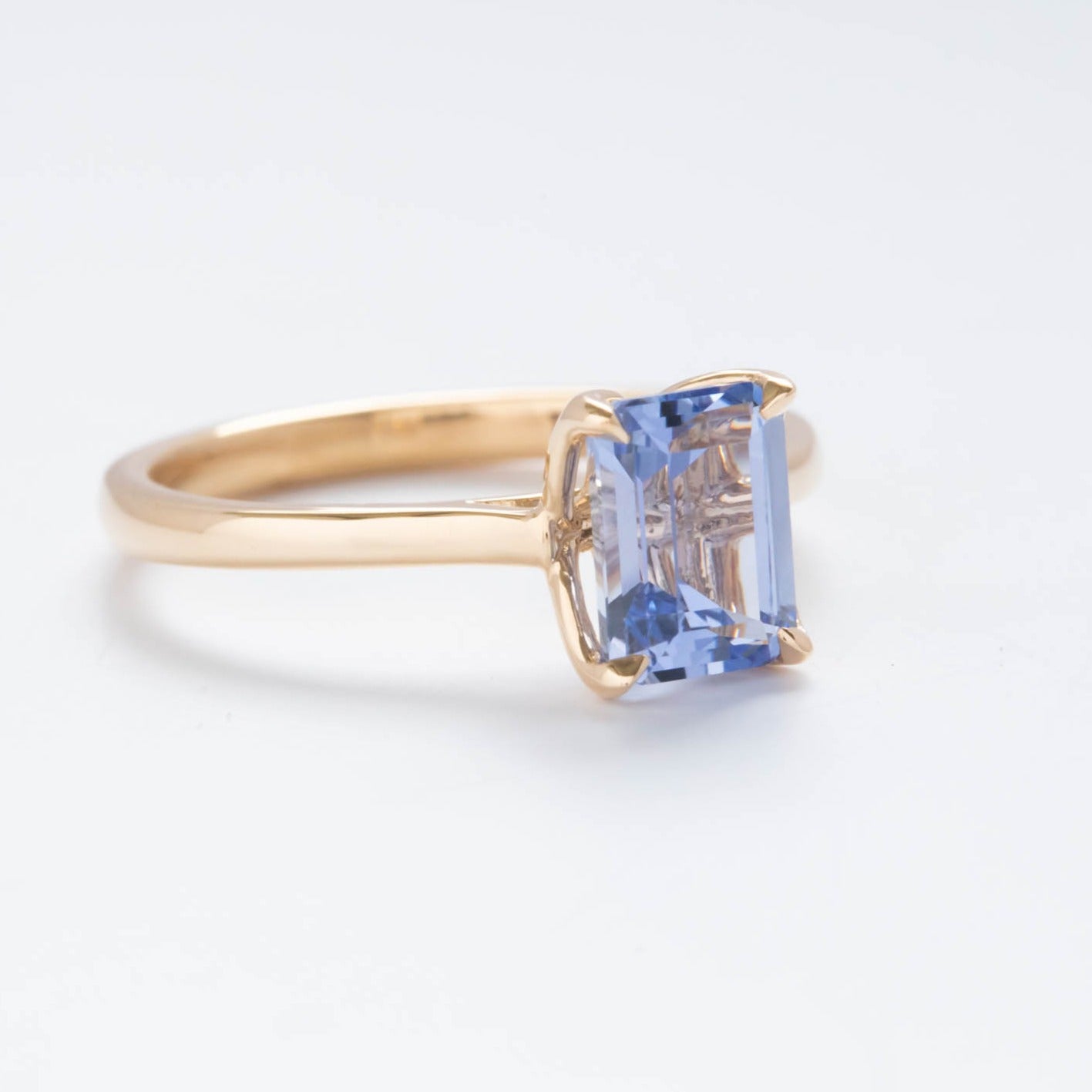 floral inspired solitaire engagement ring with step cut lab sapphire