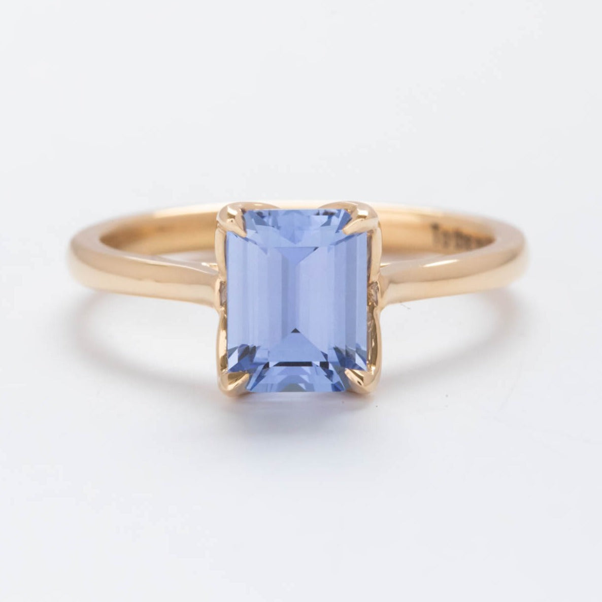 floral inspired solitaire engagement ring with step cut lab sapphire