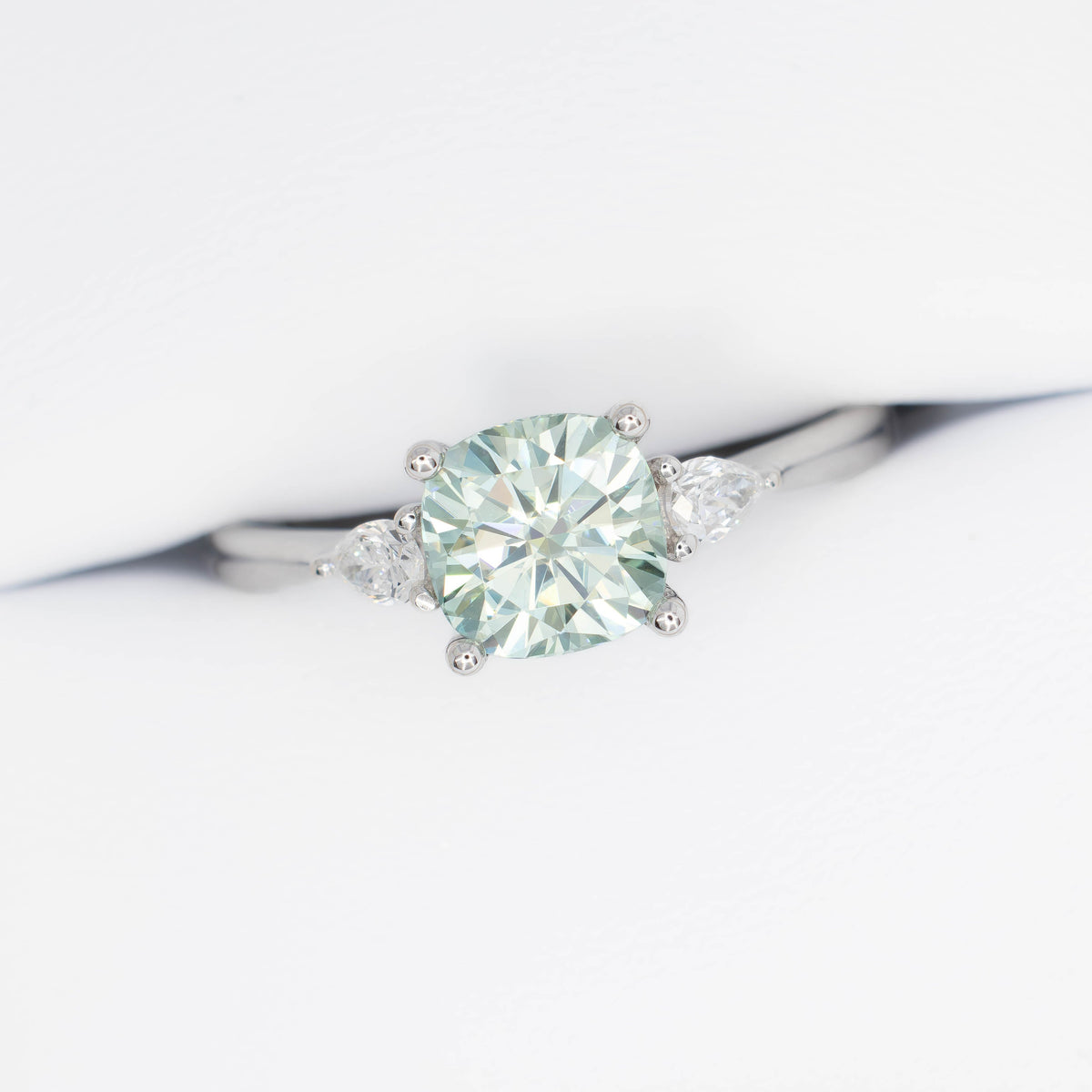 lacey three stone ring with cushion blue-green moissanite